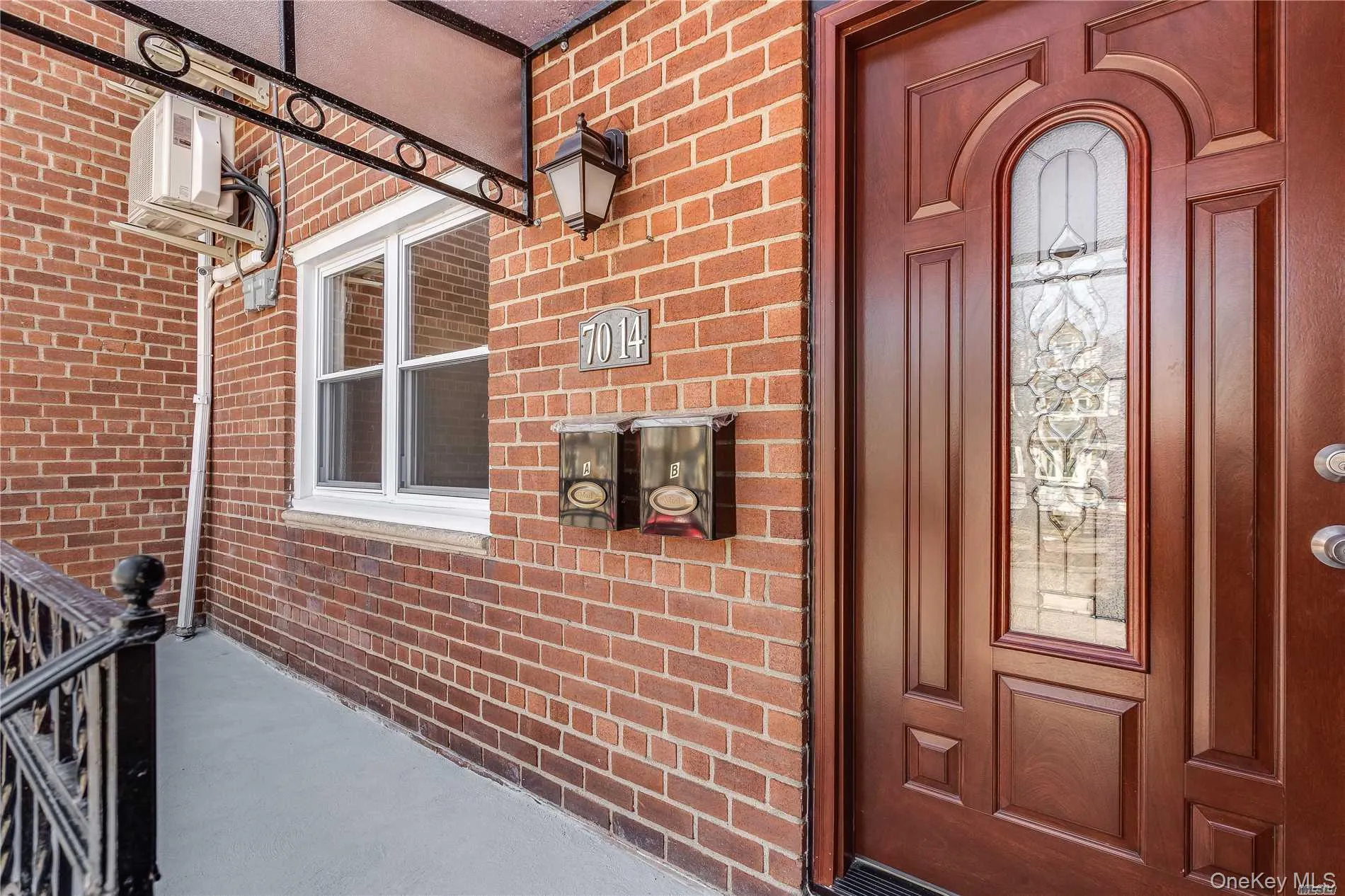 Brick facade featuring a rich wood-paneled entry door with leaded glass insert Brick facade featuring a rich wood-paneled entry door with leaded glass insert