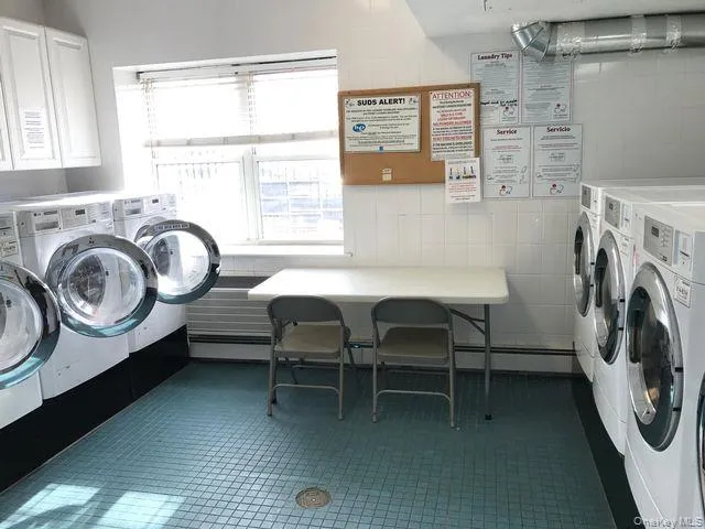 Shared laundry featuring tile walls and washer and clothes dryer Shared laundry featuring tile walls and washer and clothes dryer