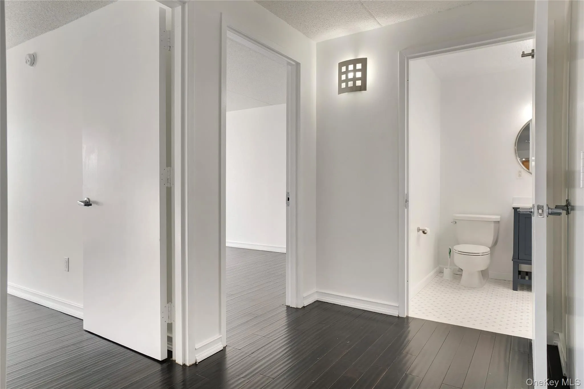 Corridor with a textured ceiling and dark wood finished floors Corridor with a textured ceiling and dark wood finished floors