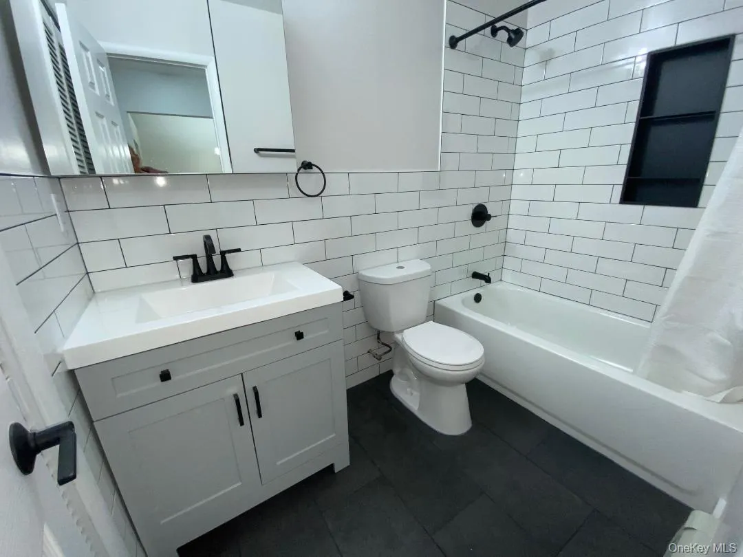 Pretty updated bathroom which features a vanity featuring a light gray shaker-style cabinet, integrated sink, and matte black hardware Pretty updated bathroom which features a vanity featuring a light gray shaker-style cabinet, integrated sink, and matte black hardware