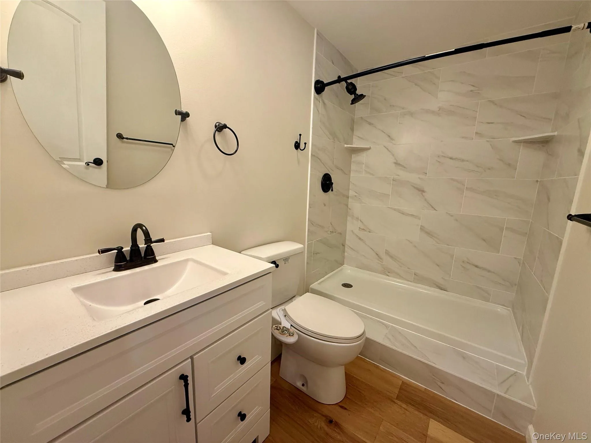 Contemporary bathroom featuring a white vanity with a quartz countertop, an integrated sink, and matte black fixtures Contemporary bathroom featuring a white vanity with a quartz countertop, an integrated sink, and matte black fixtures