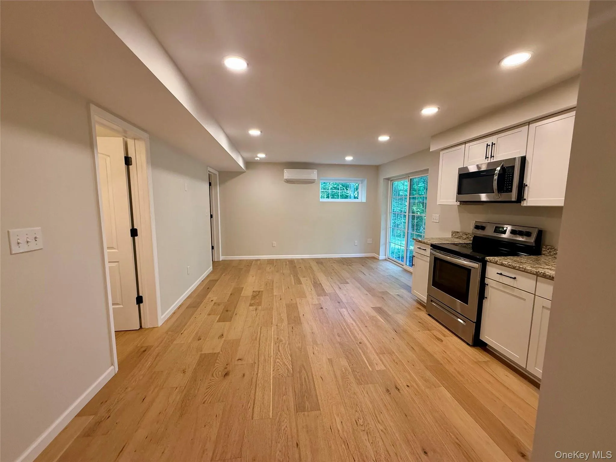 Open-concept living space with wood-finish flooring Open-concept living space with wood-finish flooring