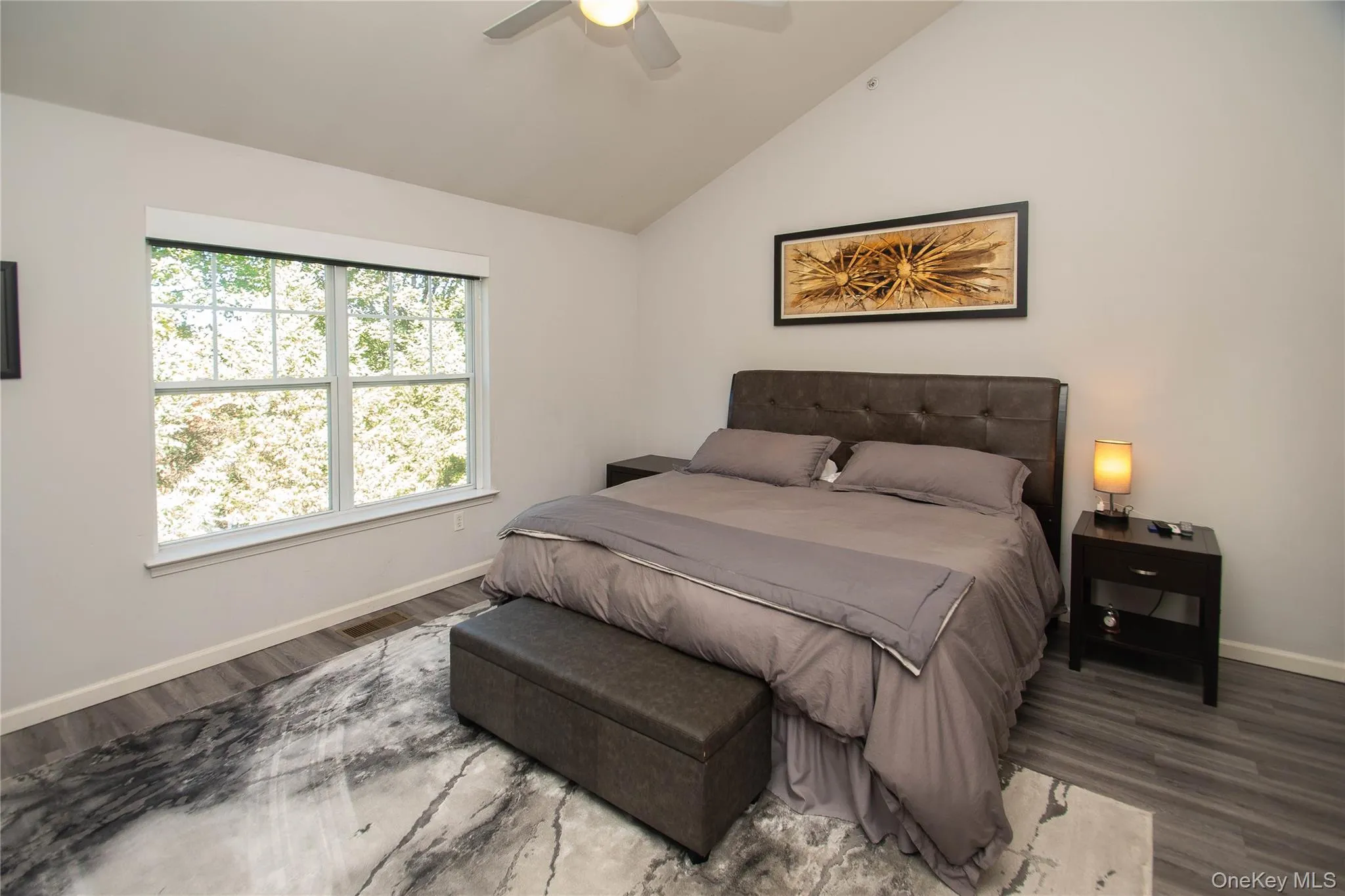 Bedroom with lofted ceiling, wood finished floors, and ceiling fan Bedroom with lofted ceiling, wood finished floors, and ceiling fan