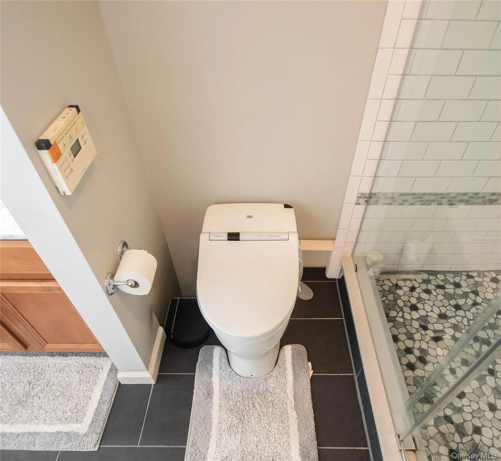 Full bath featuring a stall shower and dark tile patterned floors Full bath featuring a stall shower and dark tile patterned floors