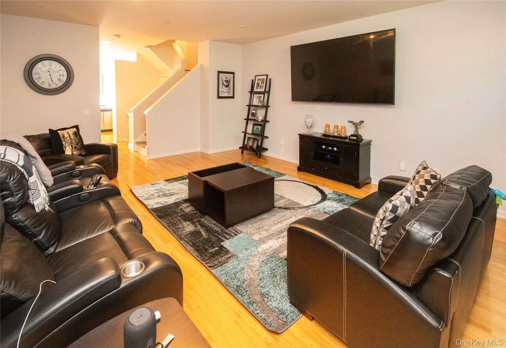 Living room featuring light wood-style floors and stairs Living room featuring light wood-style floors and stairs