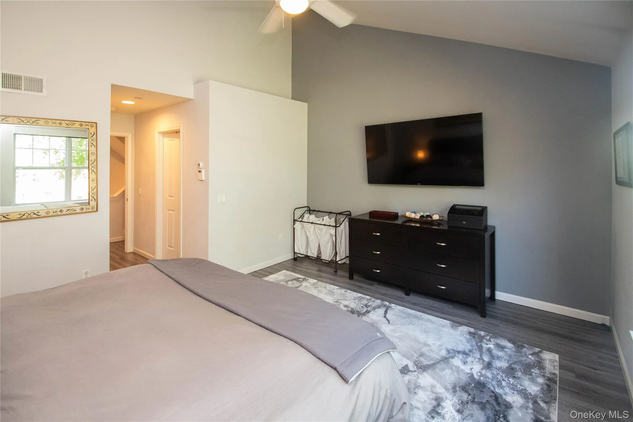 Bedroom with dark wood-type flooring, a ceiling fan, a spacious closet, high vaulted ceiling, and recessed lighting Bedroom with dark wood-type flooring, a ceiling fan, a spacious closet, high vaulted ceiling, and recessed lighting
