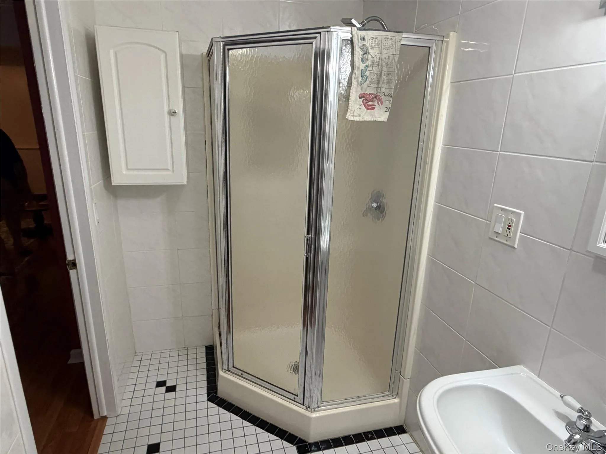 Corner shower enclosure with clear glass panels and chrome trim Corner shower enclosure with clear glass panels and chrome trim