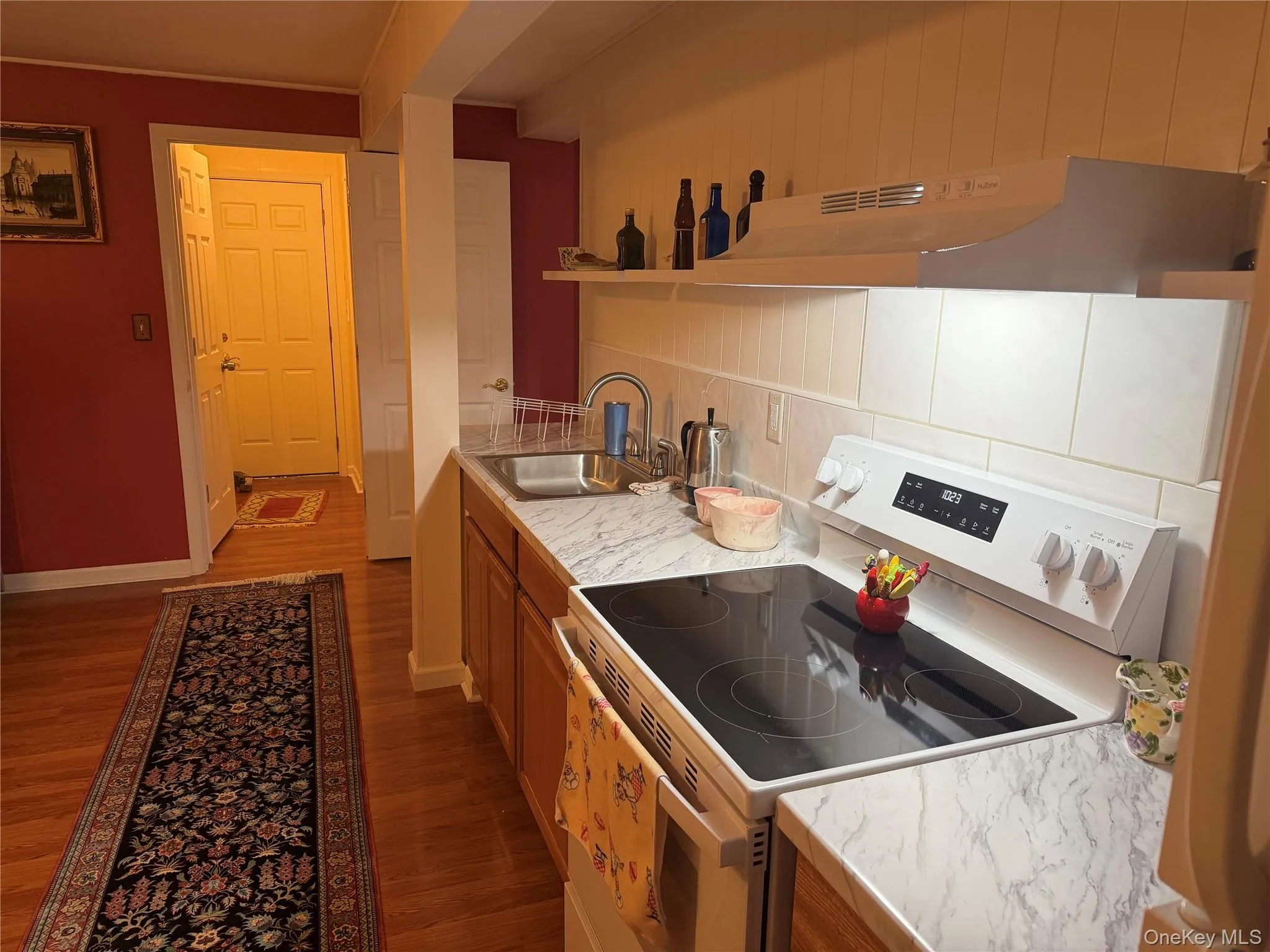 Kitchen featuring a stainless steel sink, wood-finish cabinetry, and a built-in range with a smooth cooktop Kitchen featuring a stainless steel sink, wood-finish cabinetry, and a built-in range with a smooth cooktop