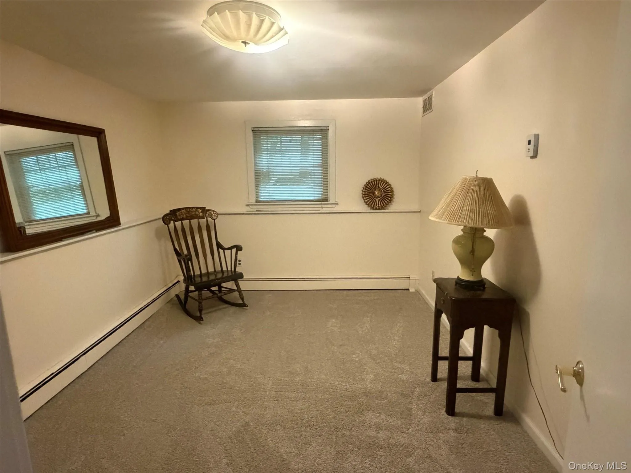 Carpeted Bedroom featuring a window with blinds, baseboard trim, and a ceiling-mounted light fixture Carpeted Bedroom featuring a window with blinds, baseboard trim, and a ceiling-mounted light fixture