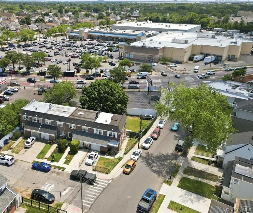 Aerial perspective showcasing residential properties near a commercial retail center Aerial perspective showcasing residential properties near a commercial retail center
