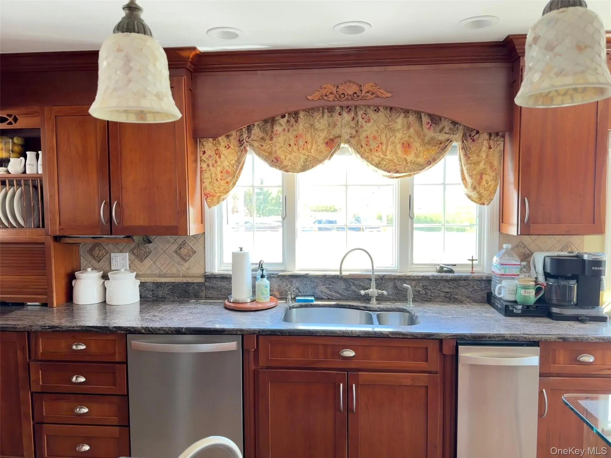 stainless steel sink with a high-arch faucet, and a window with decorative valance stainless steel sink with a high-arch faucet, and a window with decorative valance