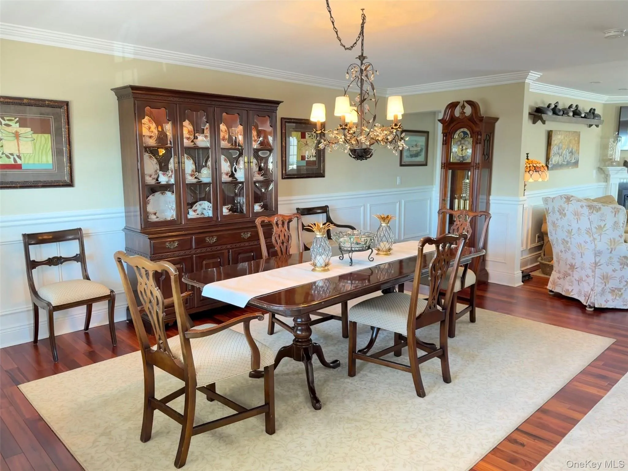 Dining area featuring wood-finish flooring, wainscoting, and crown molding Dining area featuring wood-finish flooring, wainscoting, and crown molding