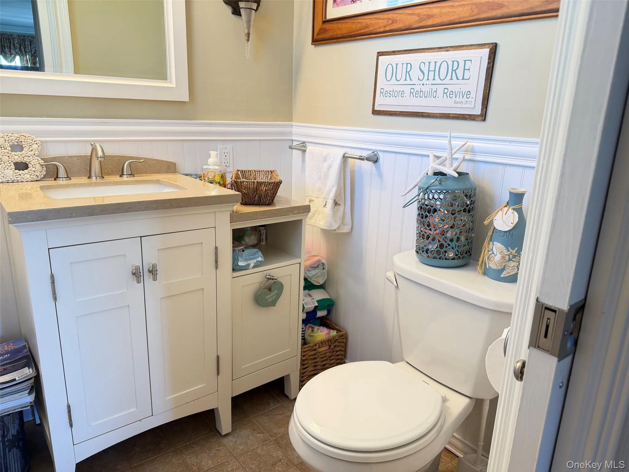 Bathroom featuring a single vanity with a light-toned countertop, white cabinetry, and a rectangular undermount sink Bathroom featuring a single vanity with a light-toned countertop, white cabinetry, and a rectangular undermount sink