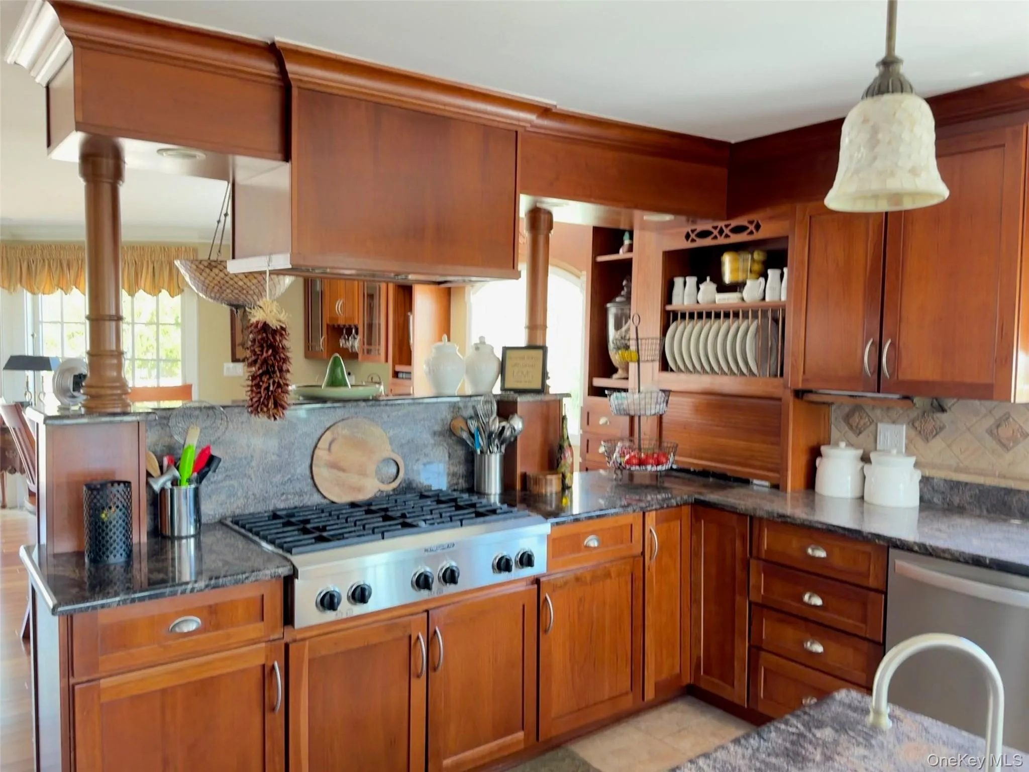 Gourmet kitchen featuring rich wood cabinetry, stainless steel range, and stone countertops Gourmet kitchen featuring rich wood cabinetry, stainless steel range, and stone countertops