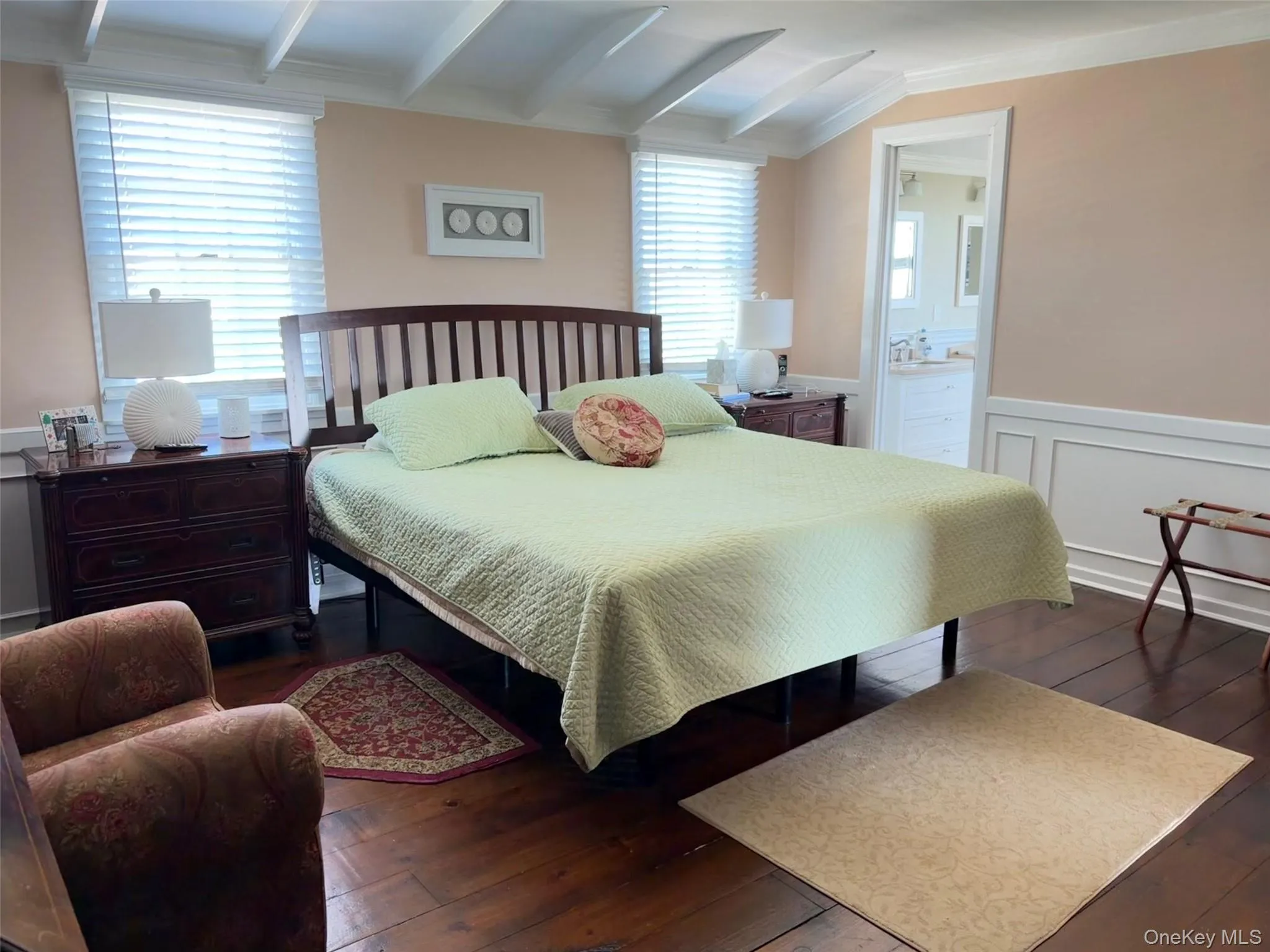 Hardwood flooring throughout this bedroom, featuring exposed beam ceilings and a framed doorway Hardwood flooring throughout this bedroom, featuring exposed beam ceilings and a framed doorway