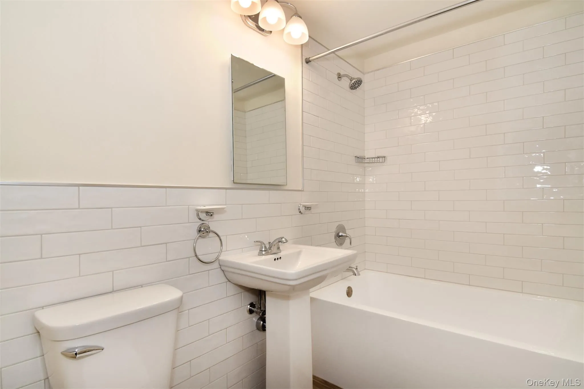 Hallway bath, newly renovated with modern flooring and subway tile. Hallway bath, newly renovated with modern flooring and subway tile.