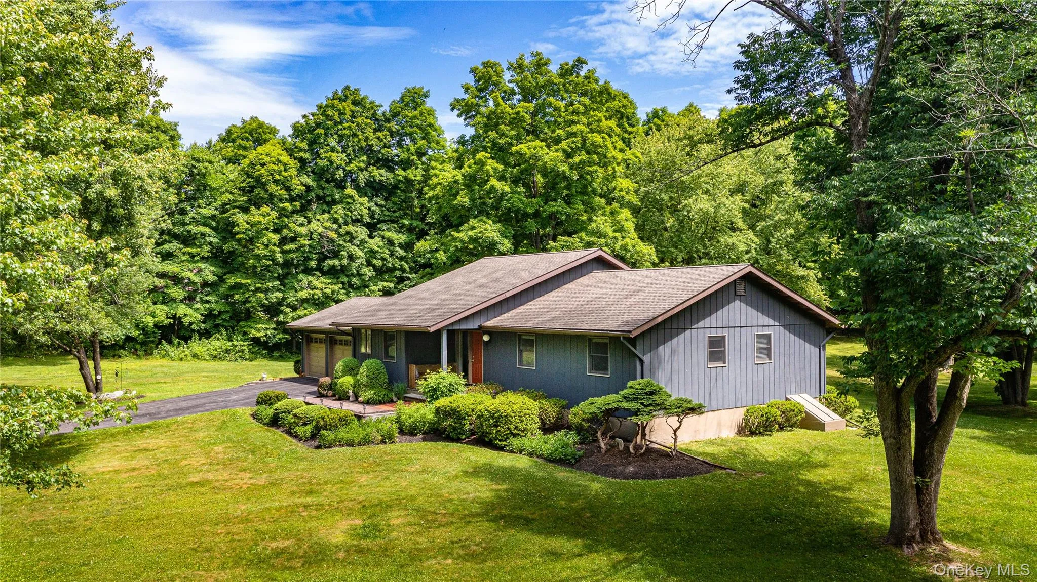 Side view of Ranch-style residence featuring a blue exterior siding and dark trim Side view of Ranch-style residence featuring a blue exterior siding and dark trim