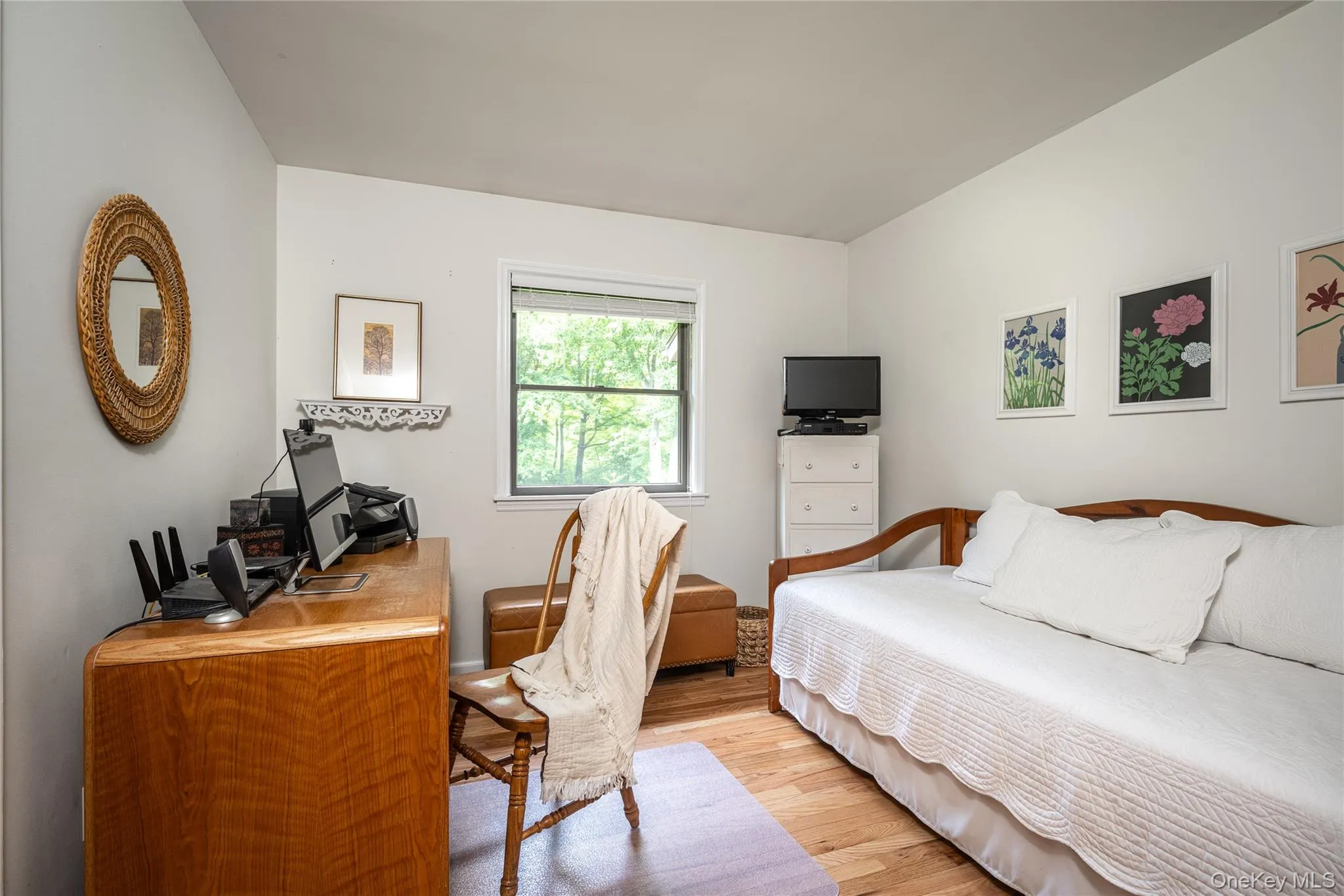 Guest Bedroom used as office. Room featuring wood-finish flooring, a window with natural light, and light-colored walls Guest Bedroom used as office. Room featuring wood-finish flooring, a window with natural light, and light-colored walls