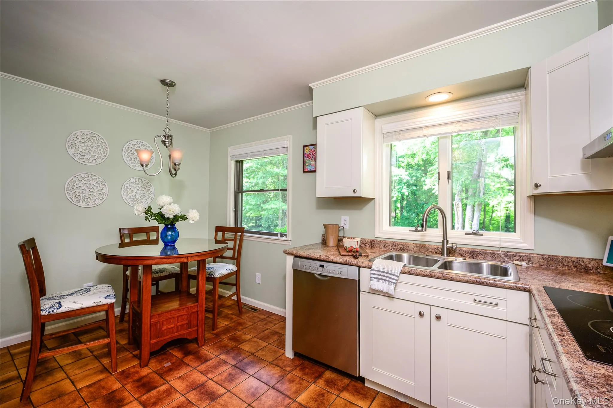 Kitchen featuring white cabinetry, a double basin stainless steel sink, stainless steel dishwasher, and a built-in cooktop Kitchen featuring white cabinetry, a double basin stainless steel sink, stainless steel dishwasher, and a built-in cooktop