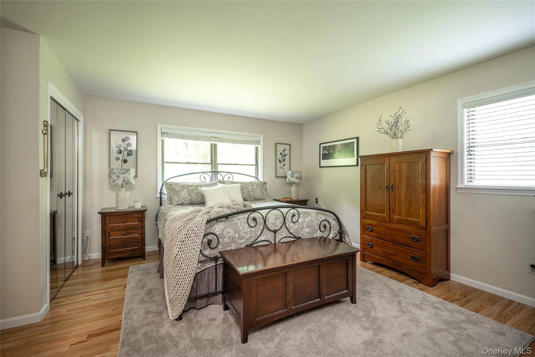 Bright room featuring wood-finish flooring, light-toned walls, and a window with white blinds Bright room featuring wood-finish flooring, light-toned walls, and a window with white blinds
