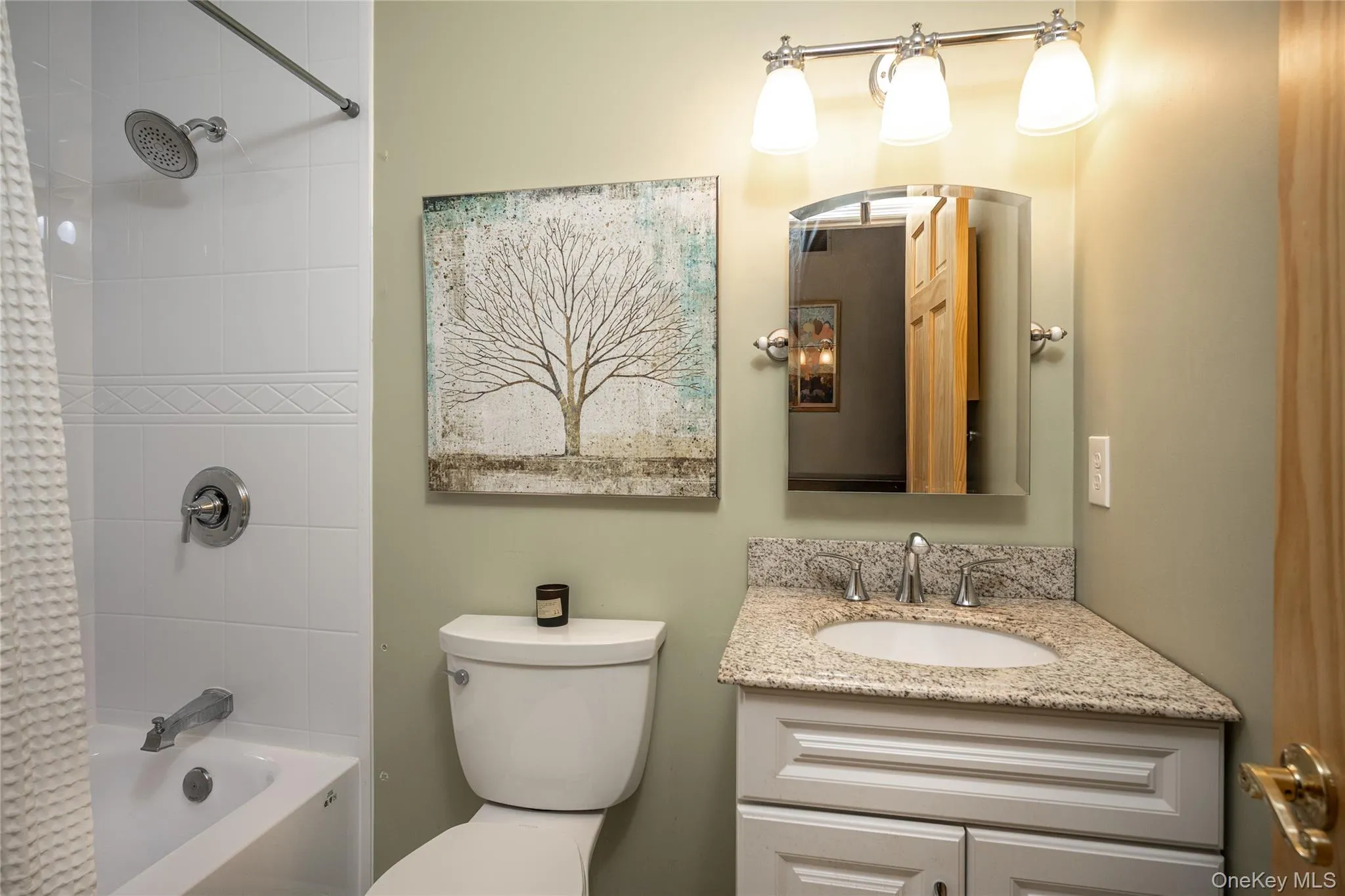 Bathroom featuring a white vanity with a granite countertop, undermount sink, and brushed nickel faucet Bathroom featuring a white vanity with a granite countertop, undermount sink, and brushed nickel faucet