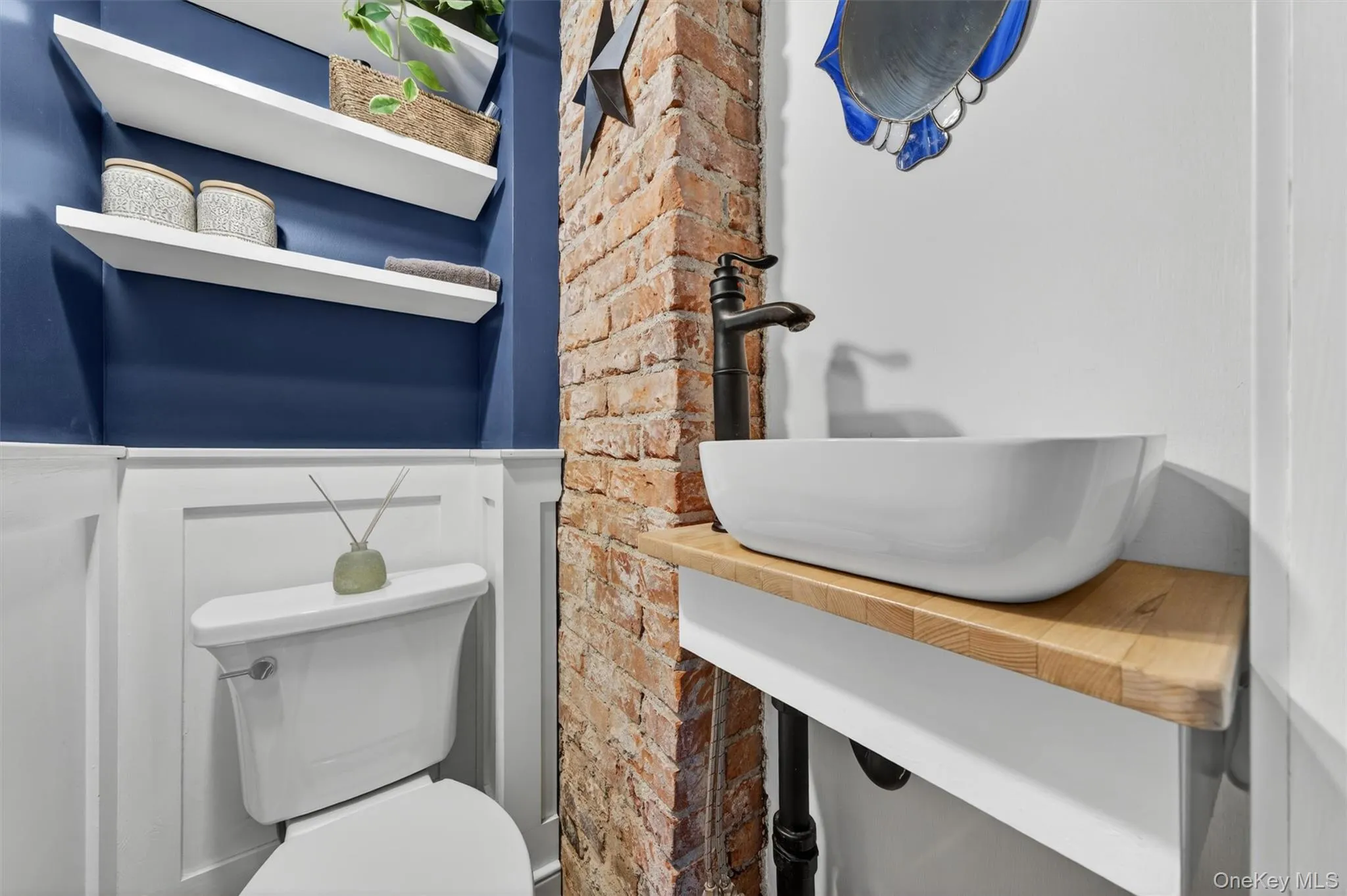 The bathroom has exposed brick and blends the old with the new. The bathroom has exposed brick and blends the old with the new.