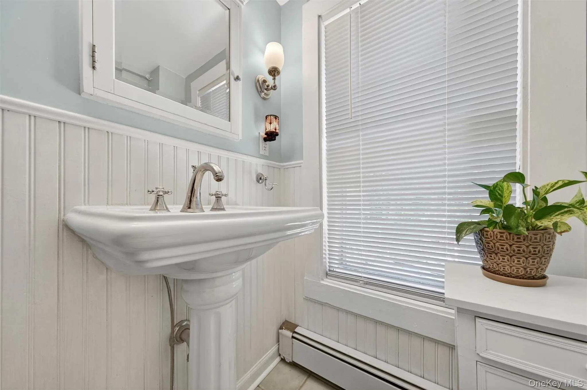 The bathroom has been updated with wainscotting and a new vanity and mirror. The bathroom has been updated with wainscotting and a new vanity and mirror.