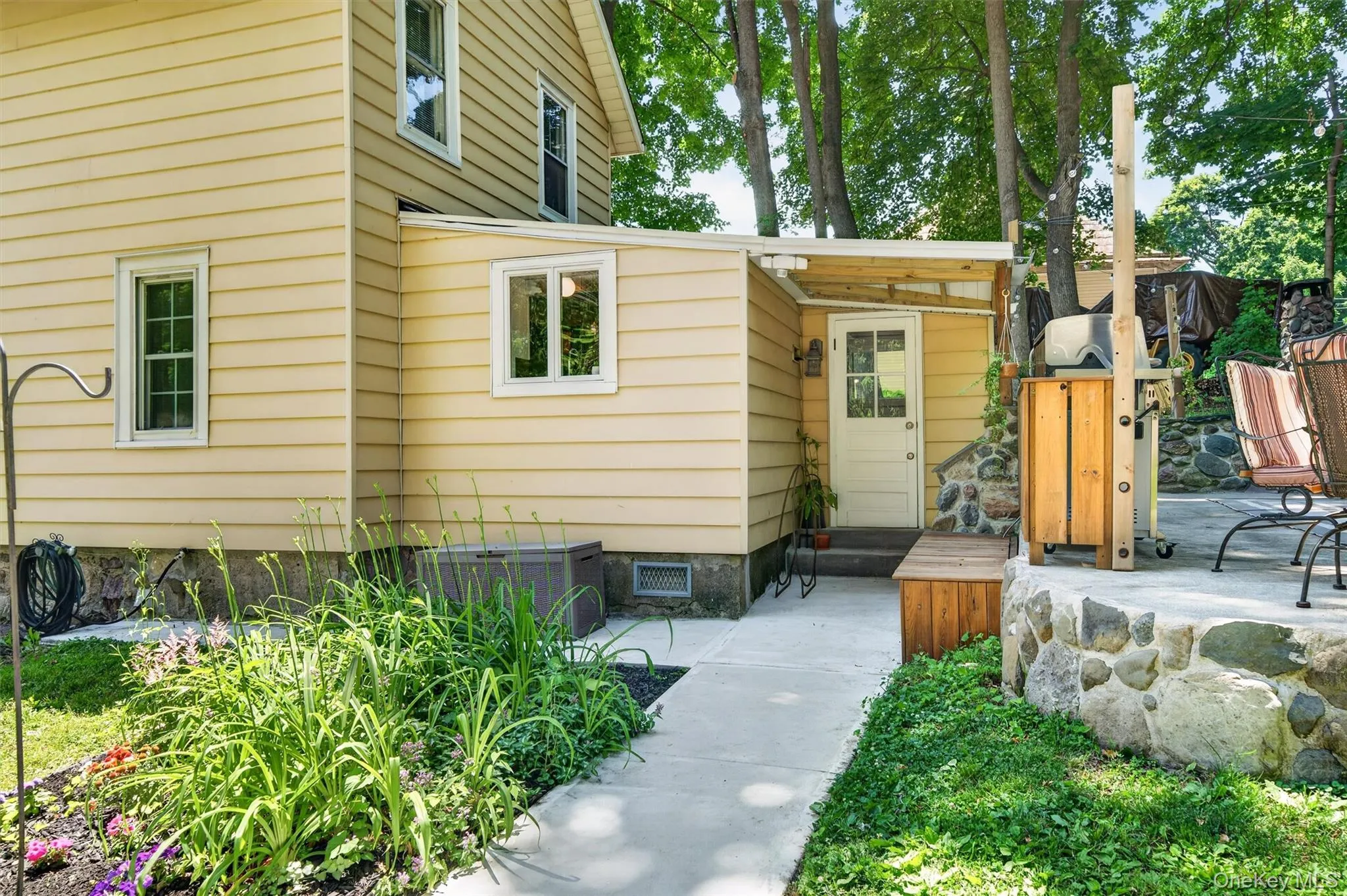 The poured concrete side walk leads to the driveway. The poured concrete side walk leads to the driveway.