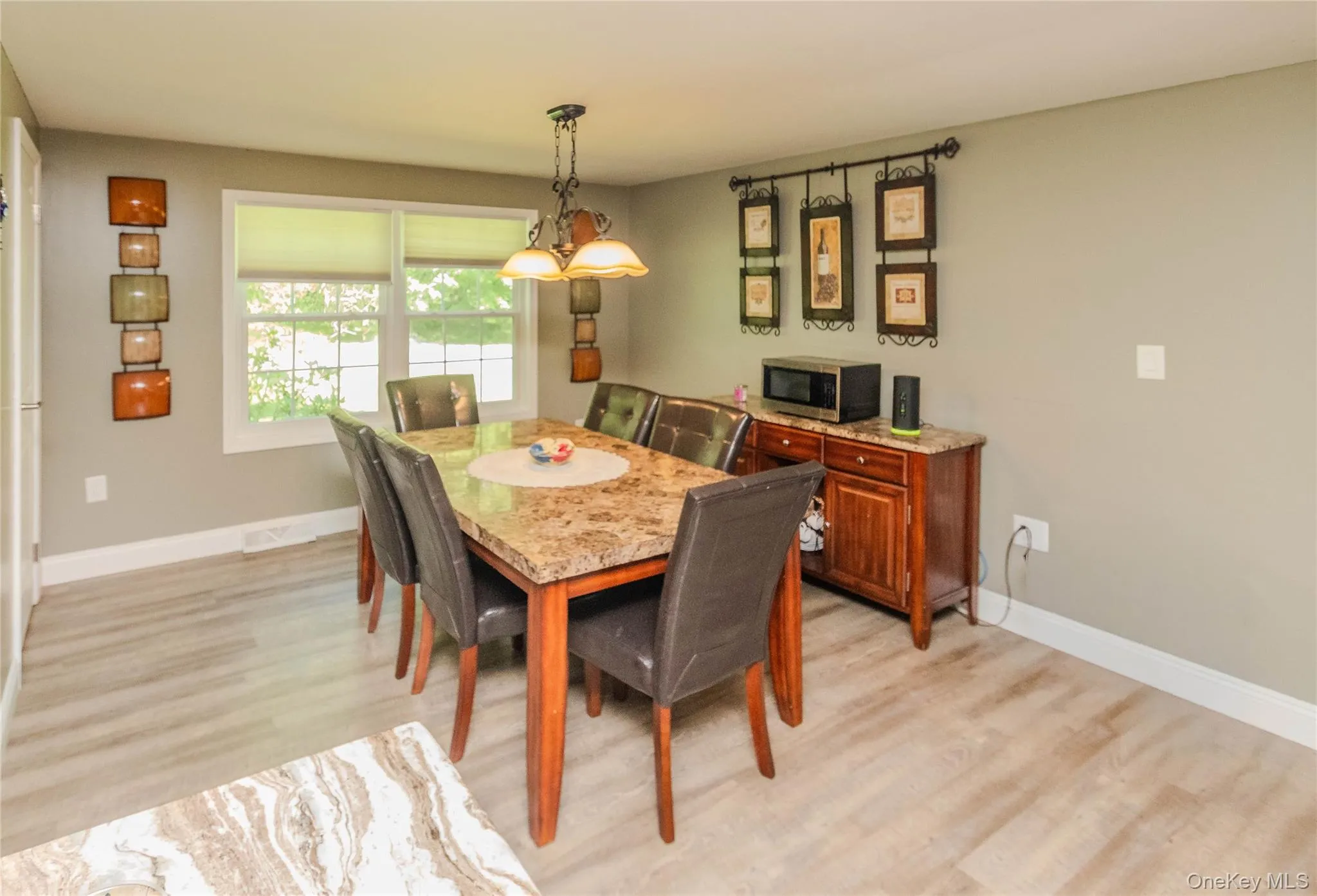 Dining area featuring light wood-finish flooring, neutral wall tones, and white trim Dining area featuring light wood-finish flooring, neutral wall tones, and white trim