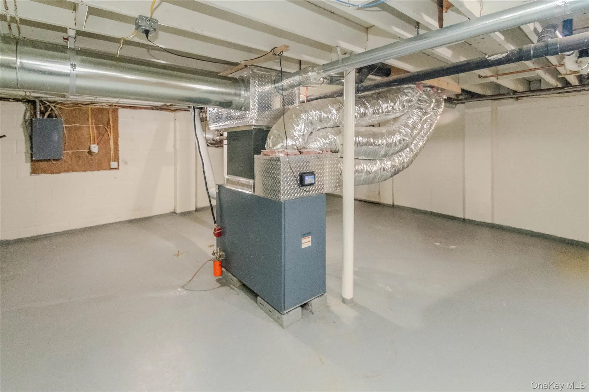 Utility room featuring a furnace system with exposed ductwork, painted concrete flooring, and exposed ceiling joists Utility room featuring a furnace system with exposed ductwork, painted concrete flooring, and exposed ceiling joists
