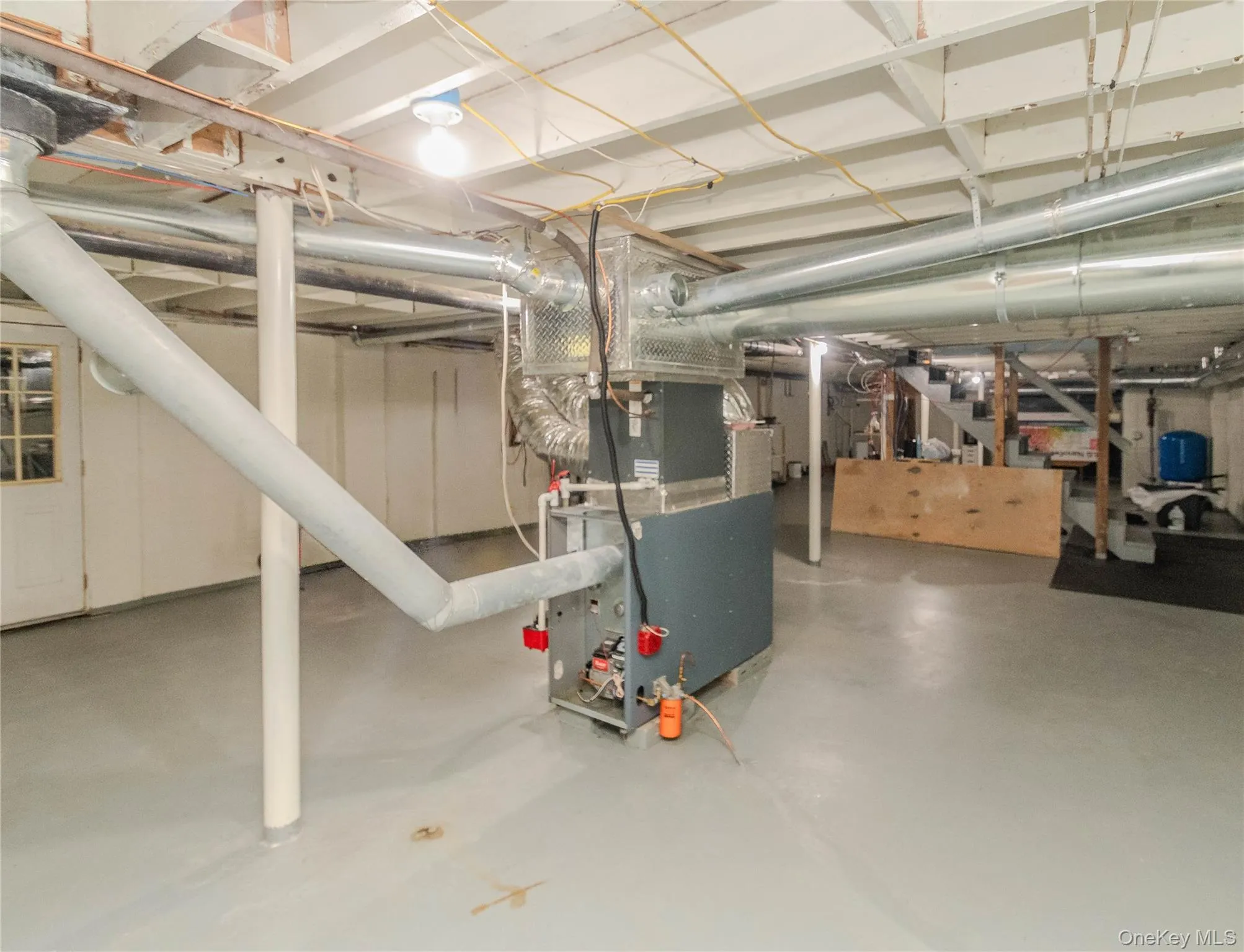 Utility room featuring a furnace system, exposed ductwork, and a painted concrete floor Utility room featuring a furnace system, exposed ductwork, and a painted concrete floor