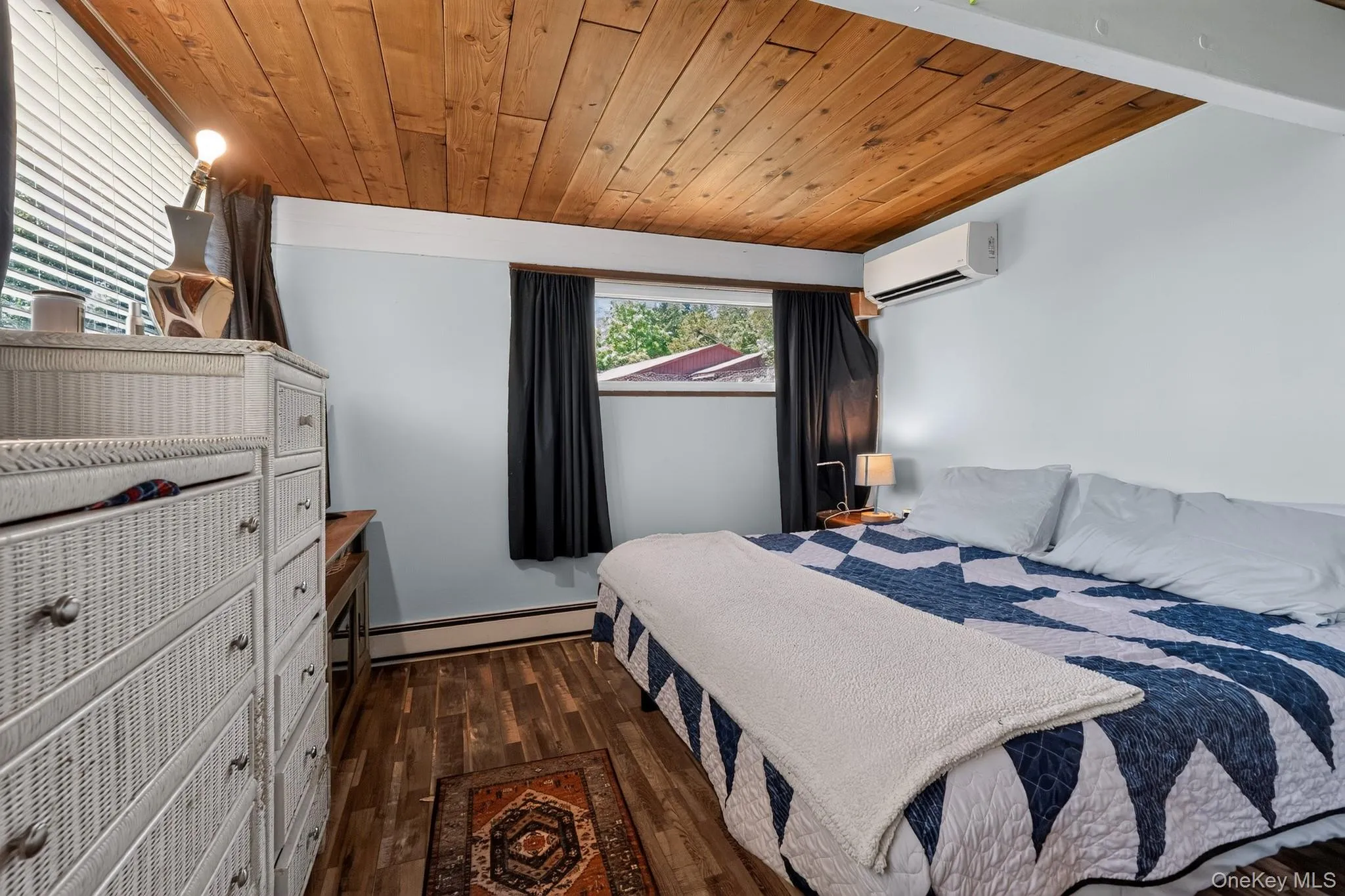 Room featuring wood-finish flooring, a natural wood paneled ceiling, and light blue walls Room featuring wood-finish flooring, a natural wood paneled ceiling, and light blue walls