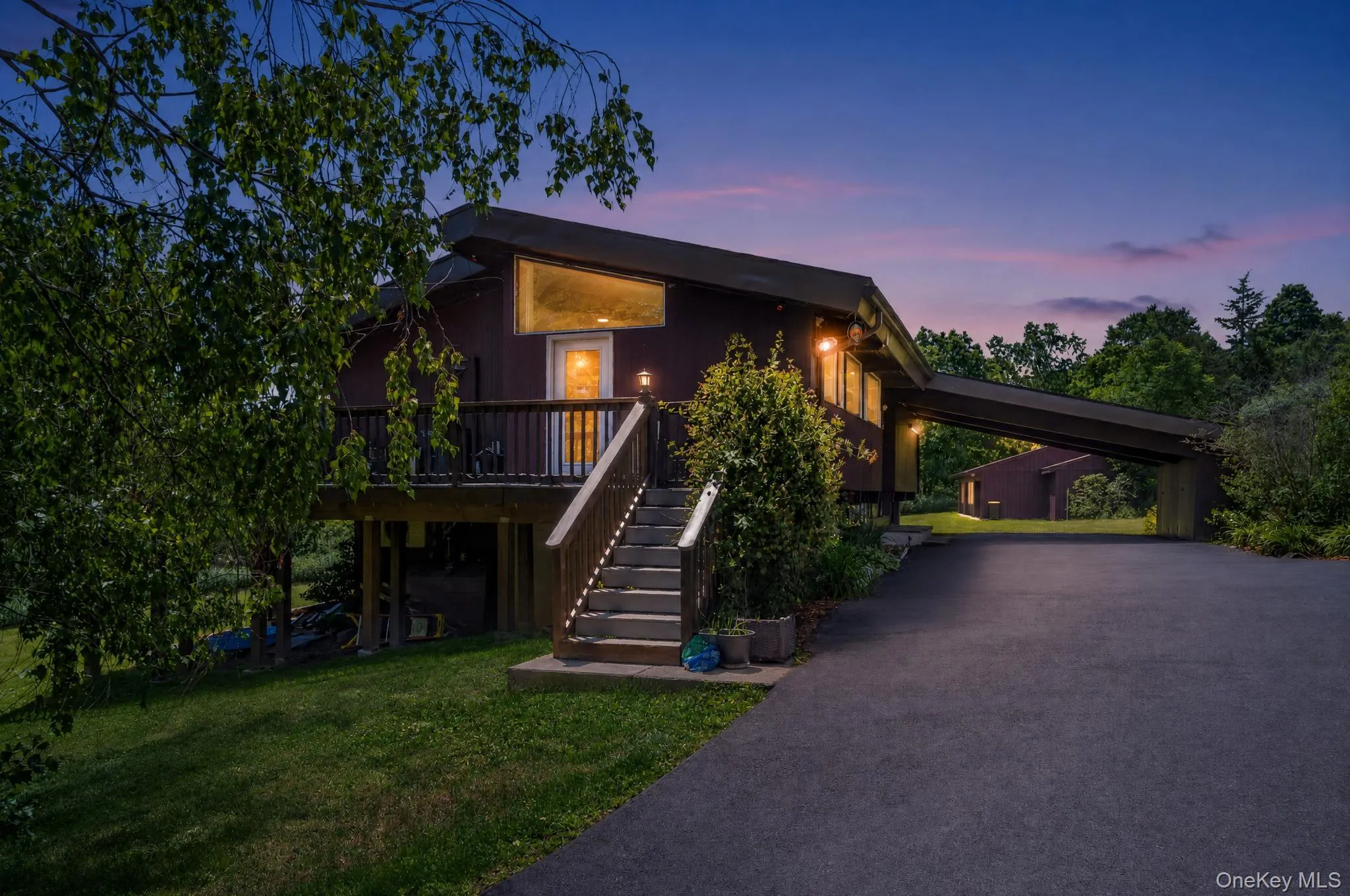 Contemporary-style residence featuring a dark exterior, elevated deck, and prominent exterior staircase Contemporary-style residence featuring a dark exterior, elevated deck, and prominent exterior staircase