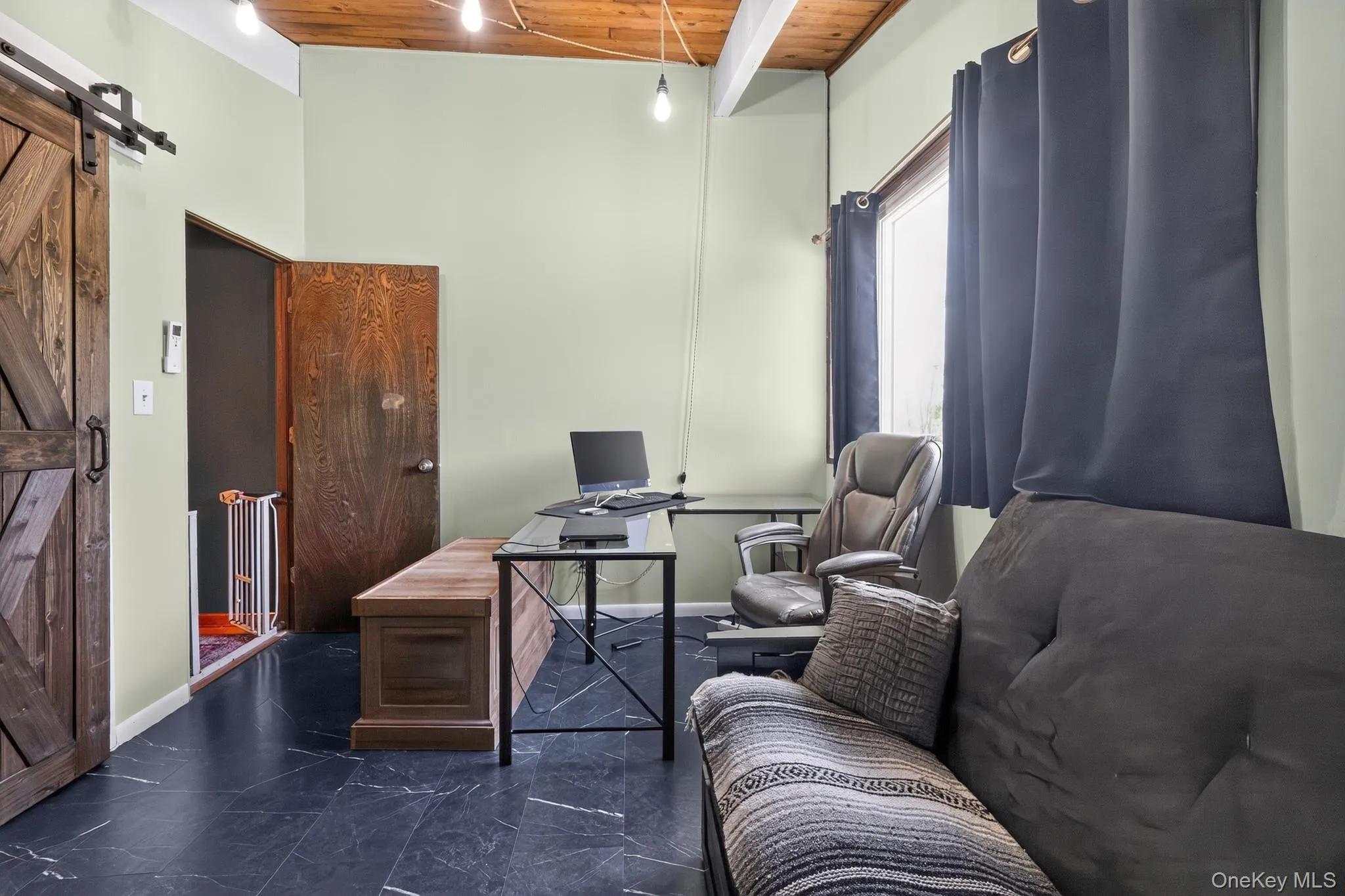 Room featuring wood-finish ceiling, exposed beams, and a barn door Room featuring wood-finish ceiling, exposed beams, and a barn door