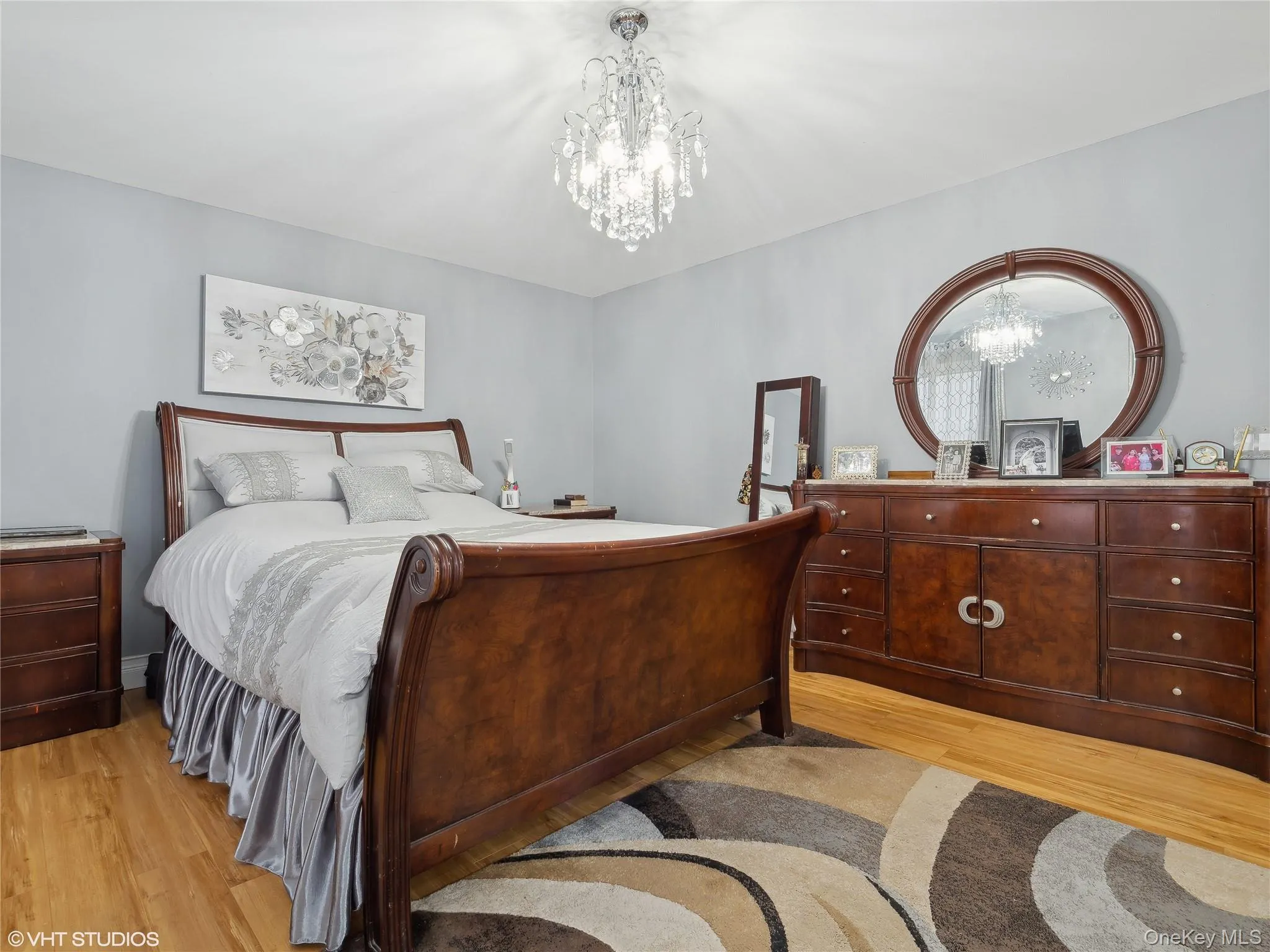 Bedroom with light hardwood / wood-style floors and a notable chandelier Bedroom with light hardwood / wood-style floors and a notable chandelier