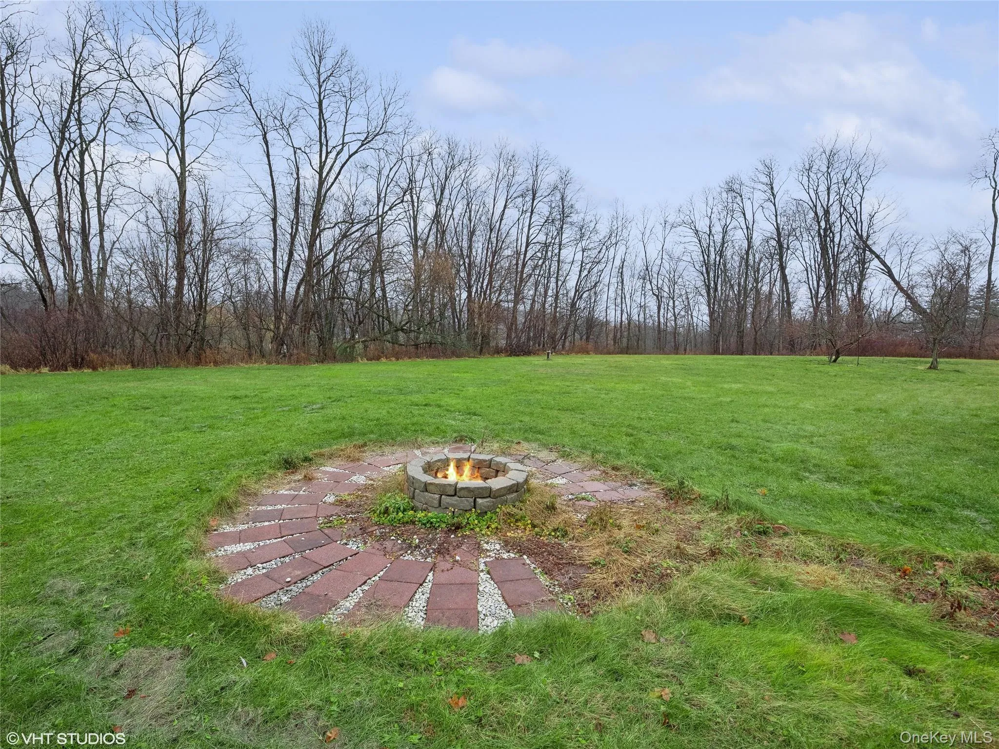 View of yard featuring an outdoor fire pit View of yard featuring an outdoor fire pit