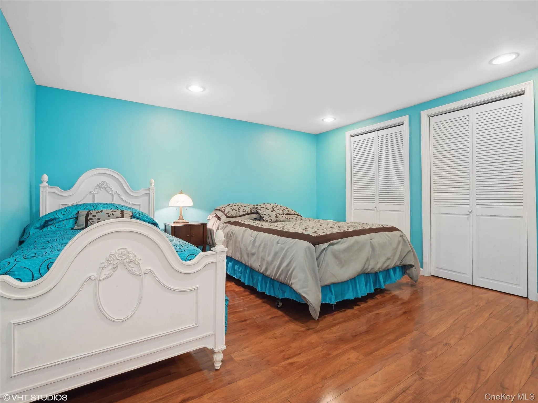 Bedroom with two closets and hardwood / wood-style flooring Bedroom with two closets and hardwood / wood-style flooring