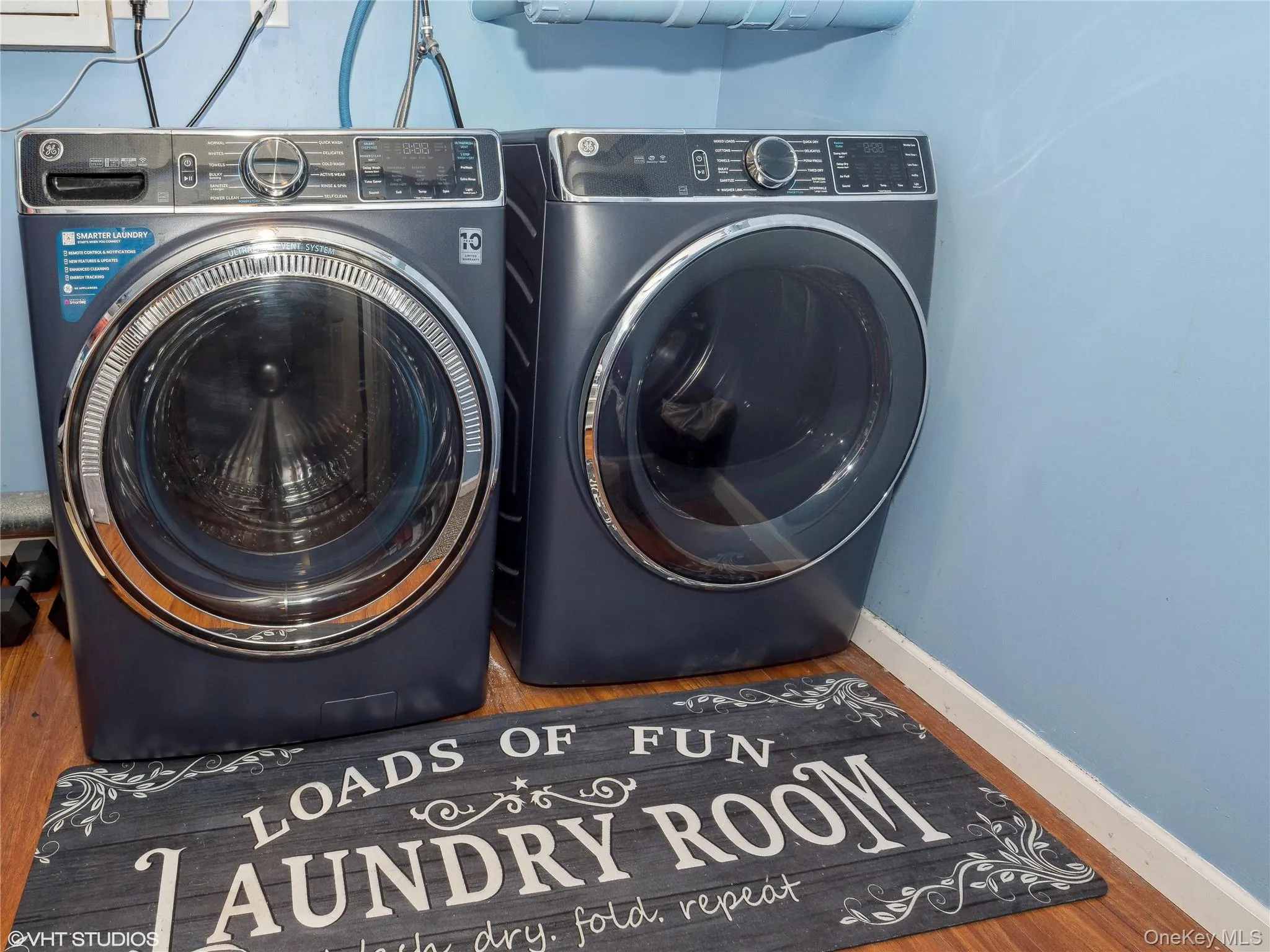 Laundry area featuring separate washer and dryer and hardwood / wood-style flooring Laundry area featuring separate washer and dryer and hardwood / wood-style flooring