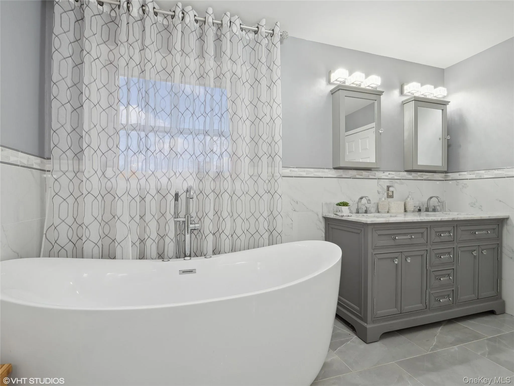 Bathroom featuring a tub, vanity, and tile walls Bathroom featuring a tub, vanity, and tile walls