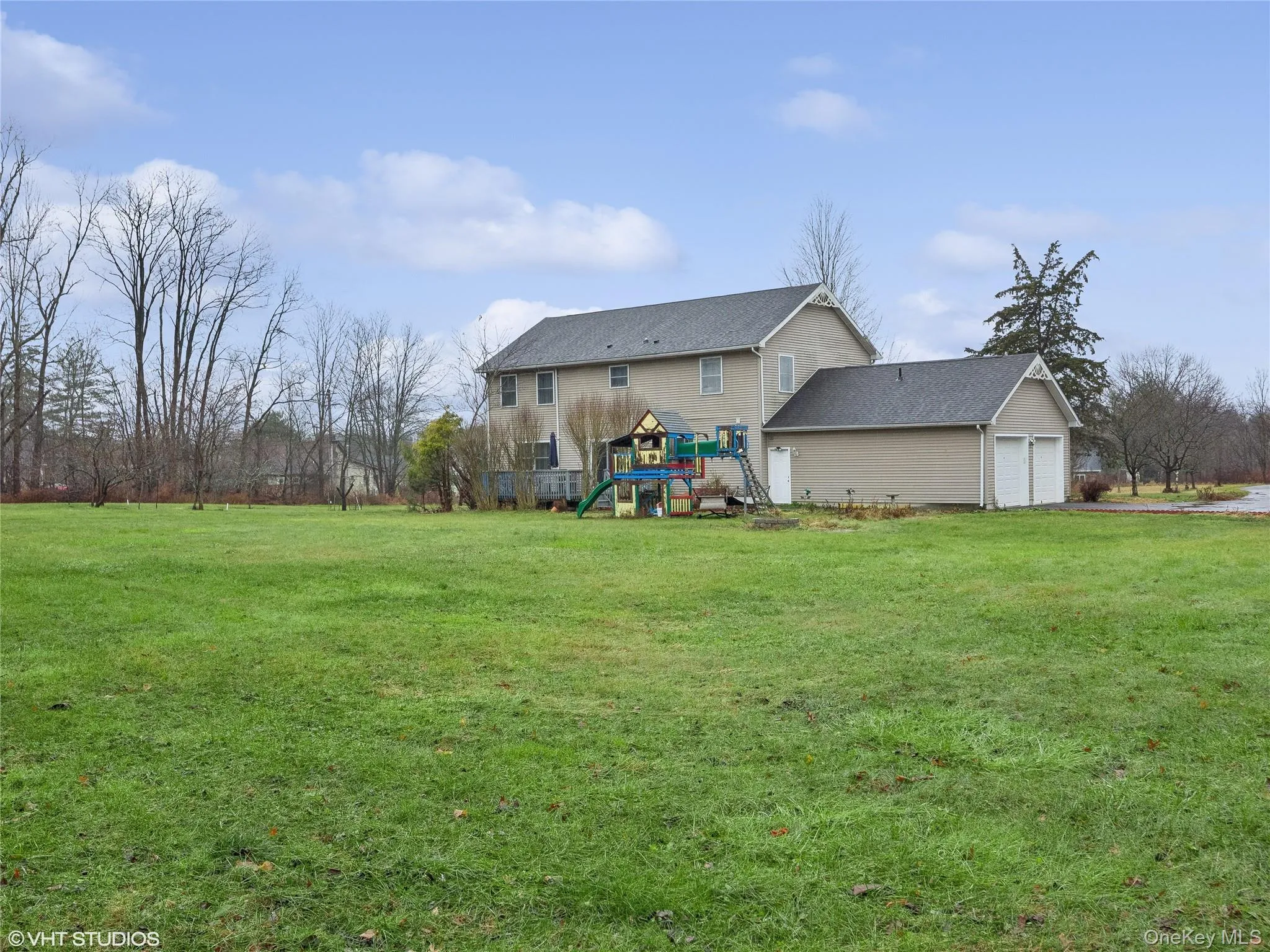 View of yard with a playground and a garage View of yard with a playground and a garage