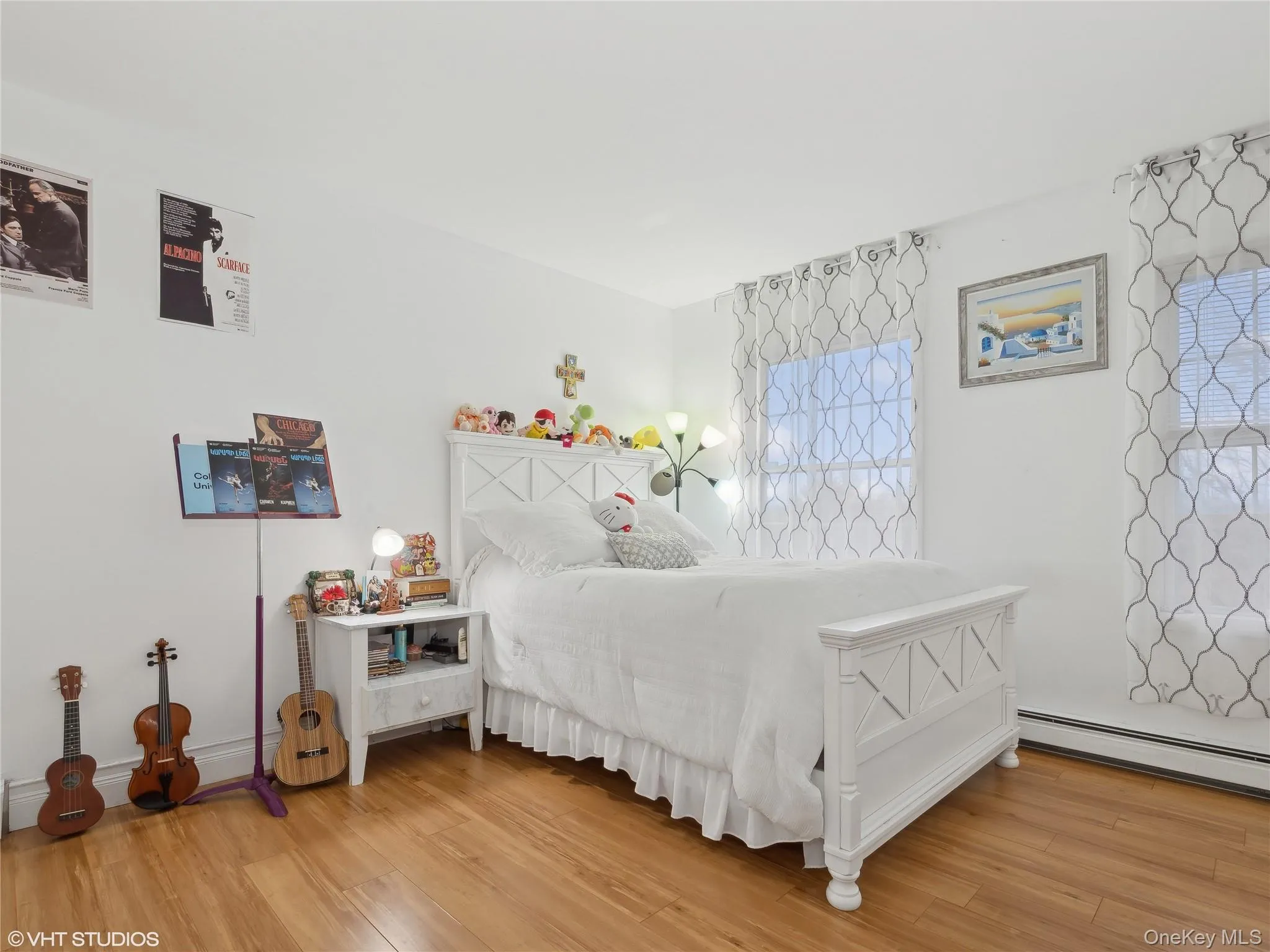 Bedroom featuring wood-type flooring and a baseboard radiator Bedroom featuring wood-type flooring and a baseboard radiator