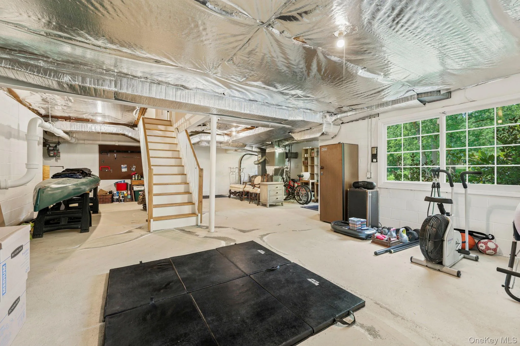 Unfinished walk-out lower level with separate entrance, high ceilings, and windows Unfinished walk-out lower level with separate entrance, high ceilings, and windows