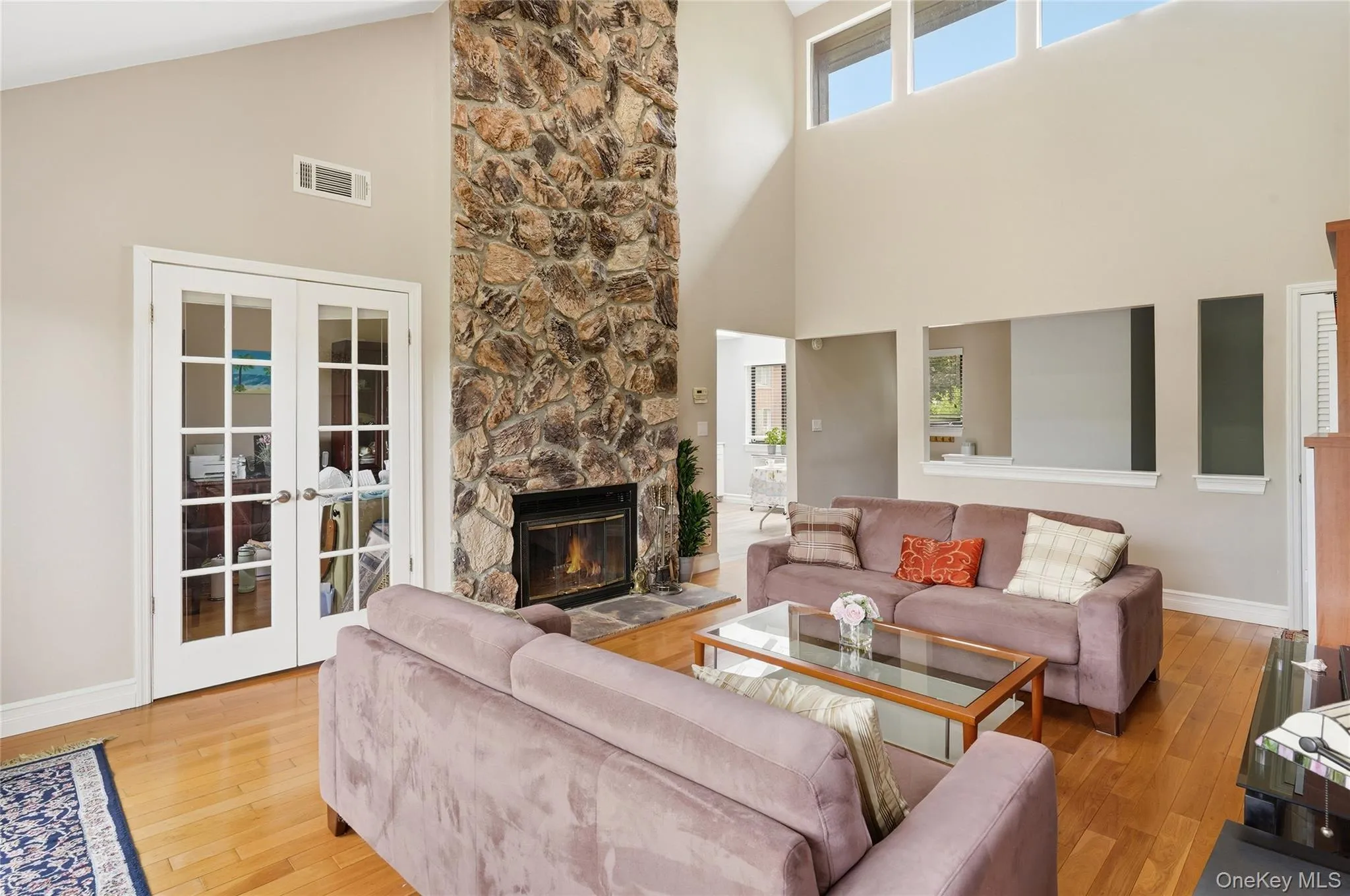Living Room with Cathedral Ceilings, skylights with stone fireplace and glass doors to view of den/2nd bedroom. Living Room with Cathedral Ceilings, skylights with stone fireplace and glass doors to view of den/2nd bedroom.