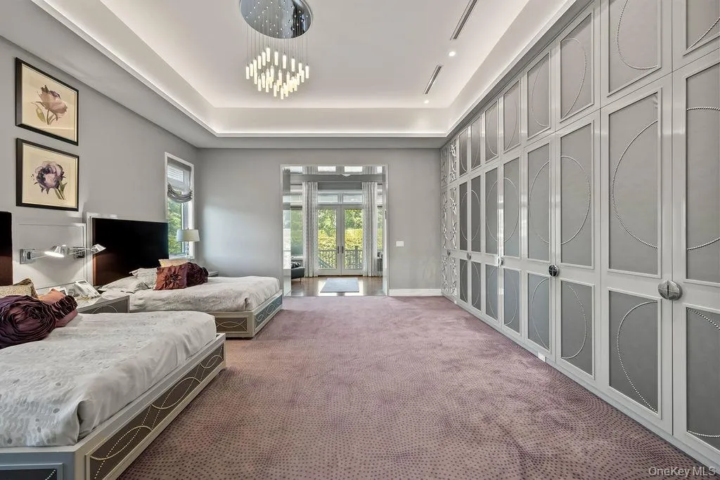 Bedroom featuring extensive built-in cabinetry, recessed lighting, and a modern chandelier Bedroom featuring extensive built-in cabinetry, recessed lighting, and a modern chandelier