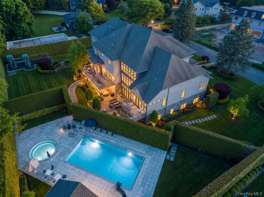 Expansive outdoor living space featuring a rectangular swimming pool, integrated spa, and paved sundeck Expansive outdoor living space featuring a rectangular swimming pool, integrated spa, and paved sundeck