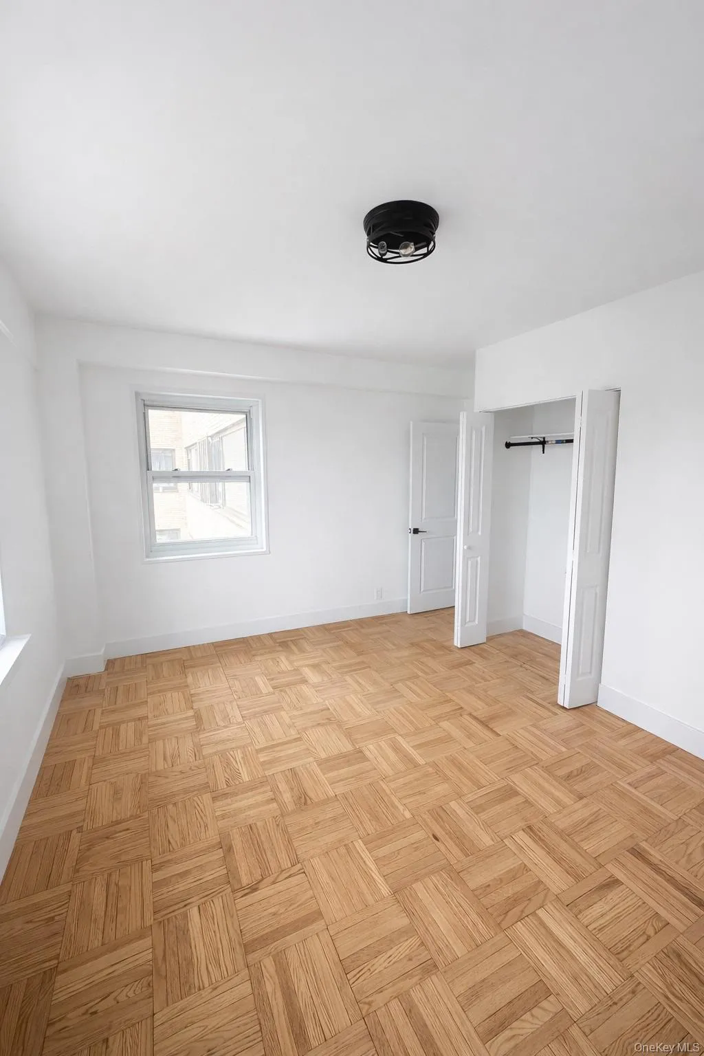 Hardwood parquet flooring defines this room, complemented by white walls and trim Hardwood parquet flooring defines this room, complemented by white walls and trim