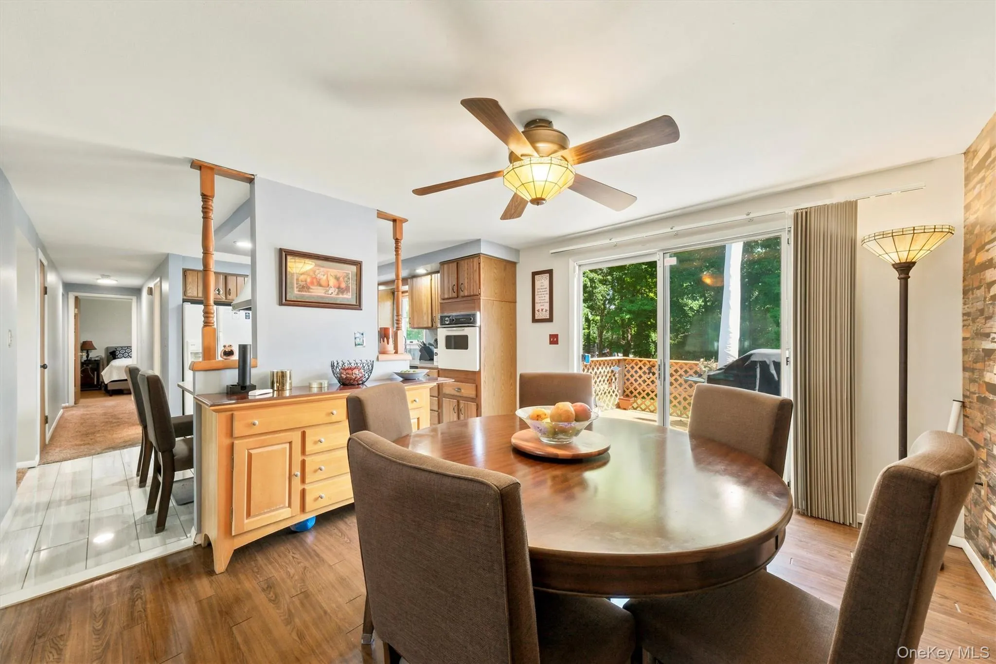 Dining area featuring wood-finish flooring, a ceiling fan with integrated lighting, and direct access to the outdoor deck through sliding glass doors Dining area featuring wood-finish flooring, a ceiling fan with integrated lighting, and direct access to the outdoor deck through sliding glass doors