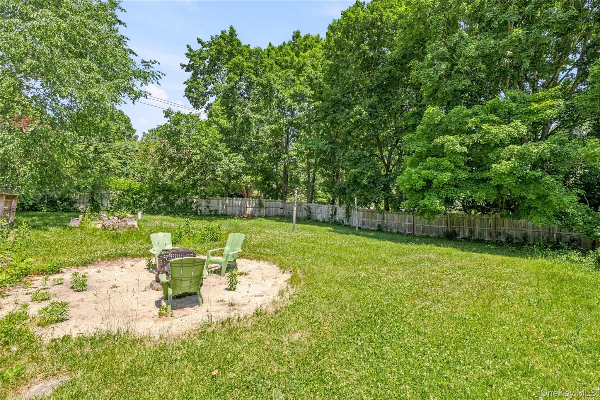 Expansive backyard featuring a large grassy area, a perimeter fence, and mature trees Expansive backyard featuring a large grassy area, a perimeter fence, and mature trees