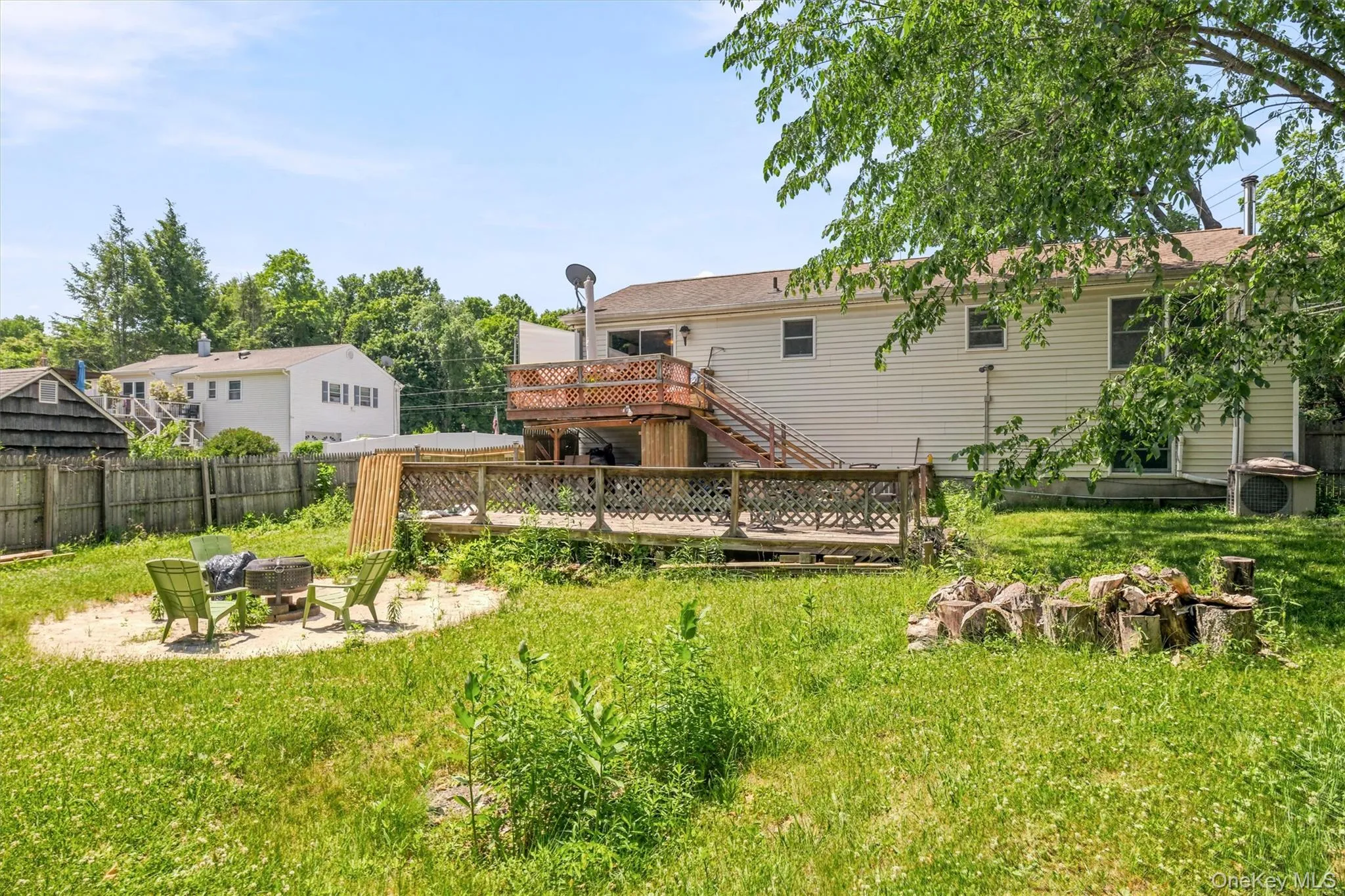 Rear exterior featuring a multi-level wooden deck with lattice accents, siding, and a ground-level patio area Rear exterior featuring a multi-level wooden deck with lattice accents, siding, and a ground-level patio area