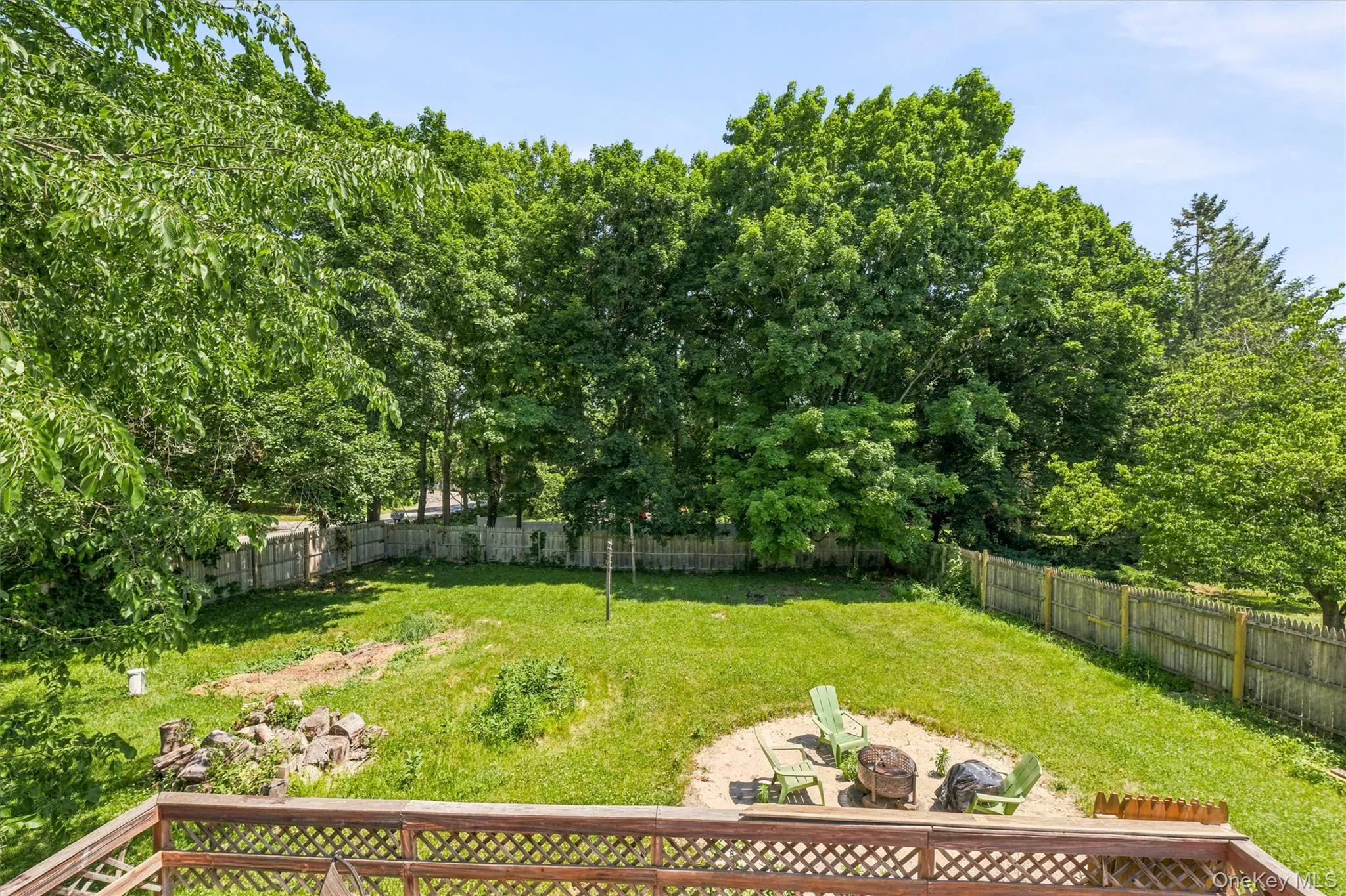 Expansive backyard featuring a combination of grass and natural ground cover, bordered by a wooden privacy fence, and mature trees providing natural screening Expansive backyard featuring a combination of grass and natural ground cover, bordered by a wooden privacy fence, and mature trees providing natural screening